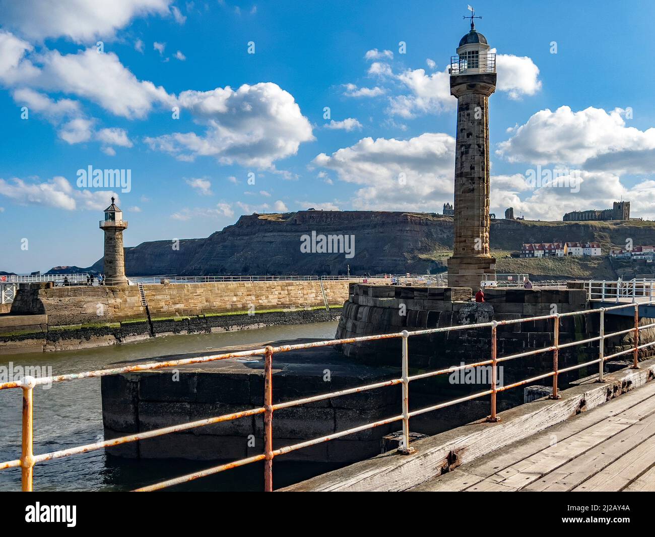 The lighthouse and pier at the entrance to the harbor in the coastal town of Whitby in North Yorkshire on the northeast coast of England. Stock Photo