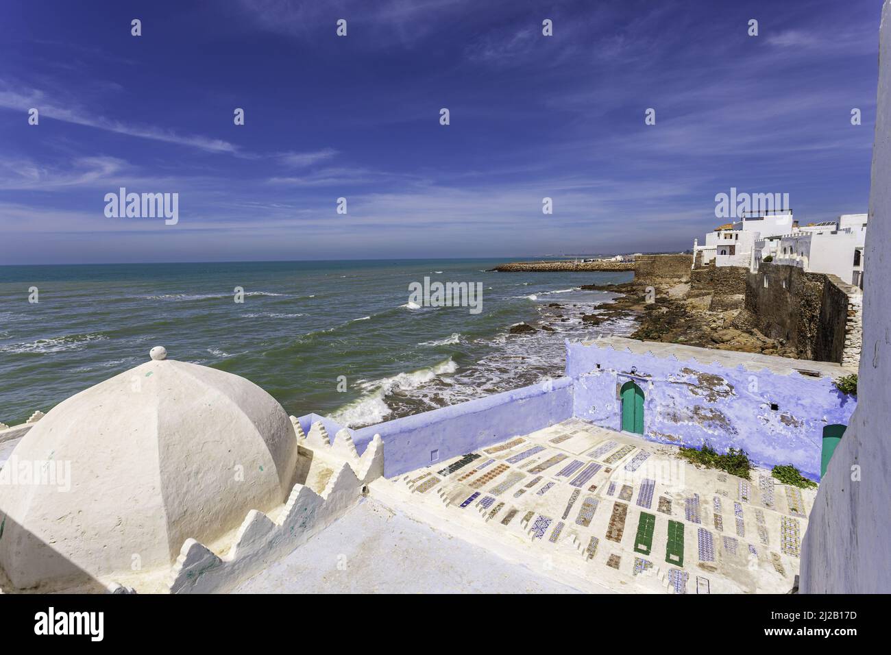 Admiring the ancient ocean front fortress of Asilah, Morocco. White and blue washed walls of houses reminding of the ancient city. Stock Photo