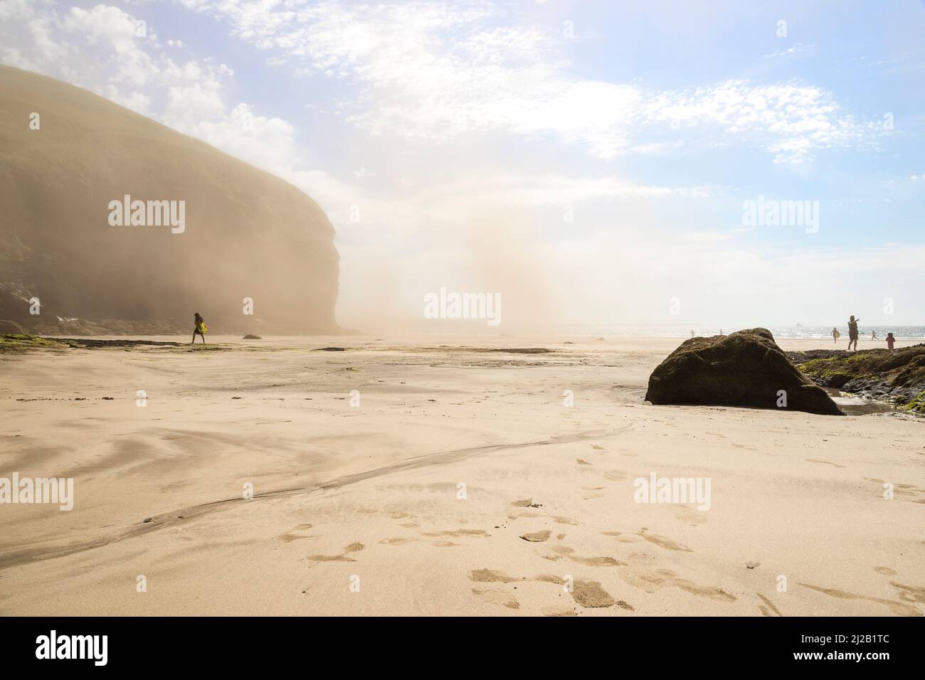 On a sunny summer day visibility is reduced at Druidstone beach in Pembrokeshire due to a cloud of dust caused by a rock fall. Stock Photo