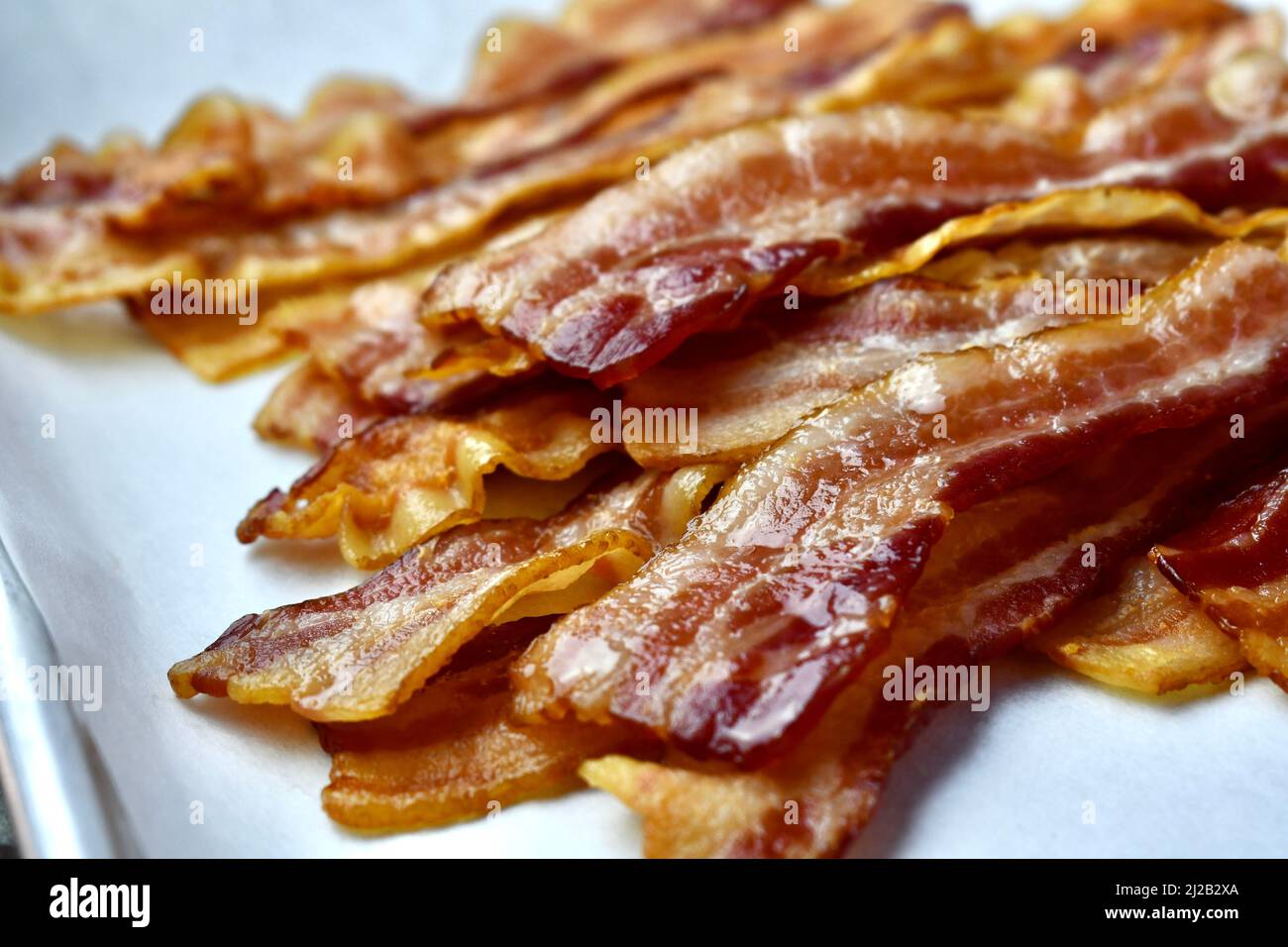 Bacon rashers on parchment lined baking pan Stock Photo