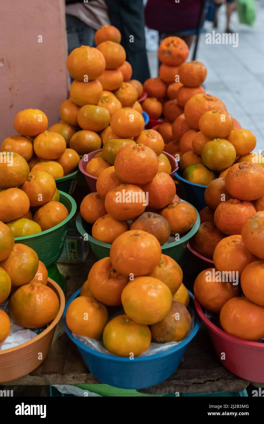 Bowls of oranges on a market in Mexico, piles of fruit, daytime Stock