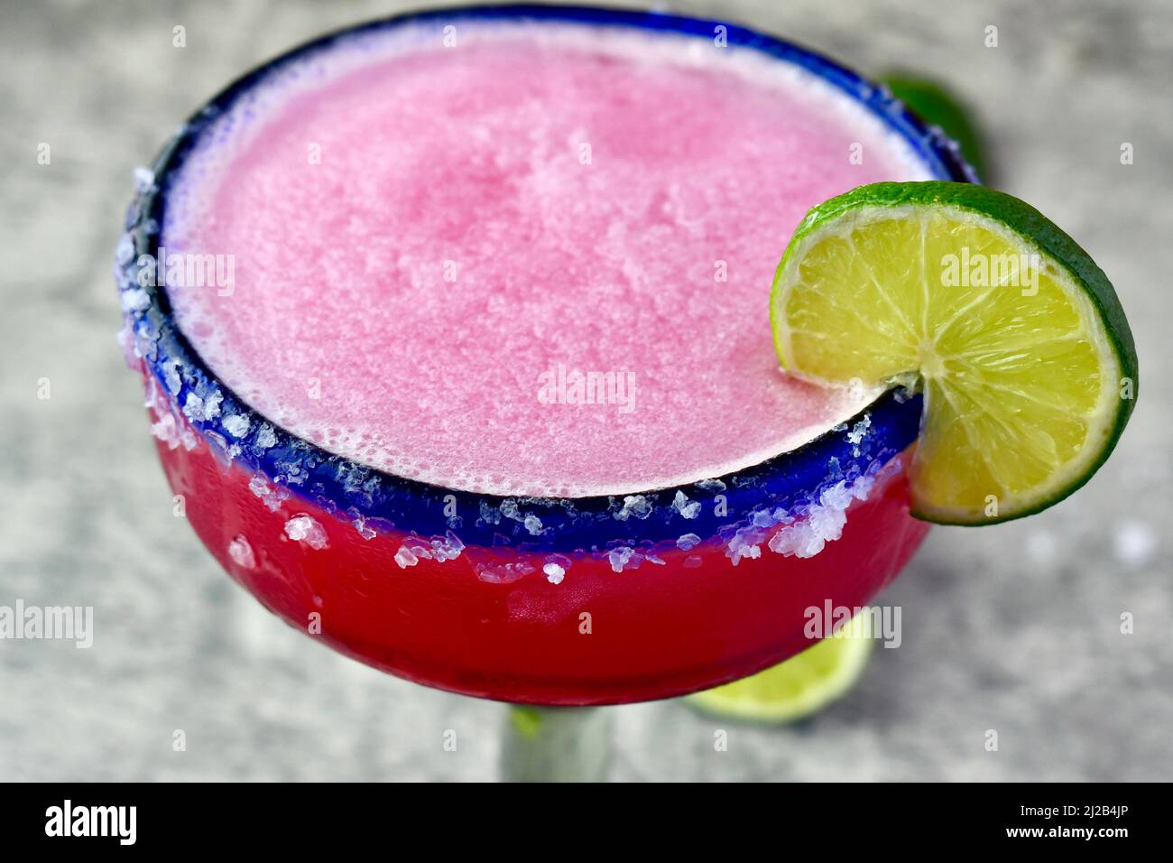 Frozen prickly pear margarita in a salted, blue rimmed glass