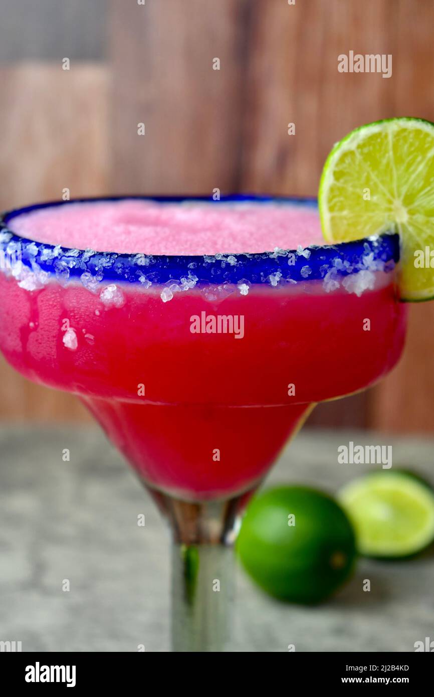 Frozen prickly pear margarita in a salted, blue rimmed glass