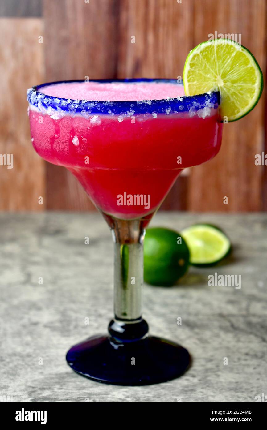 Frozen prickly pear margarita in a salted, blue rimmed glass Stock