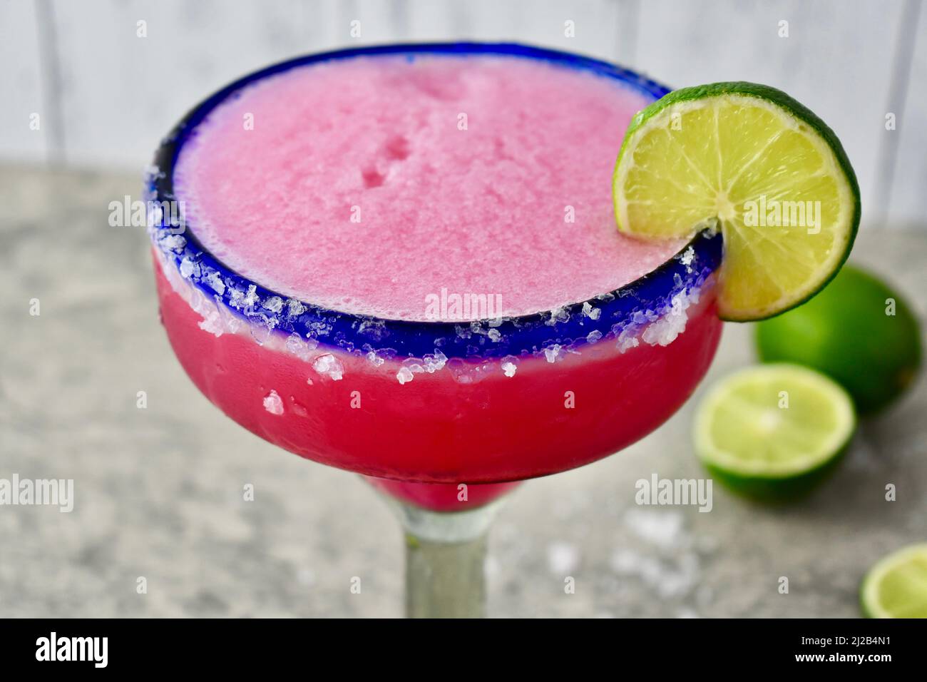 Frozen prickly pear margarita in a salted, blue rimmed glass