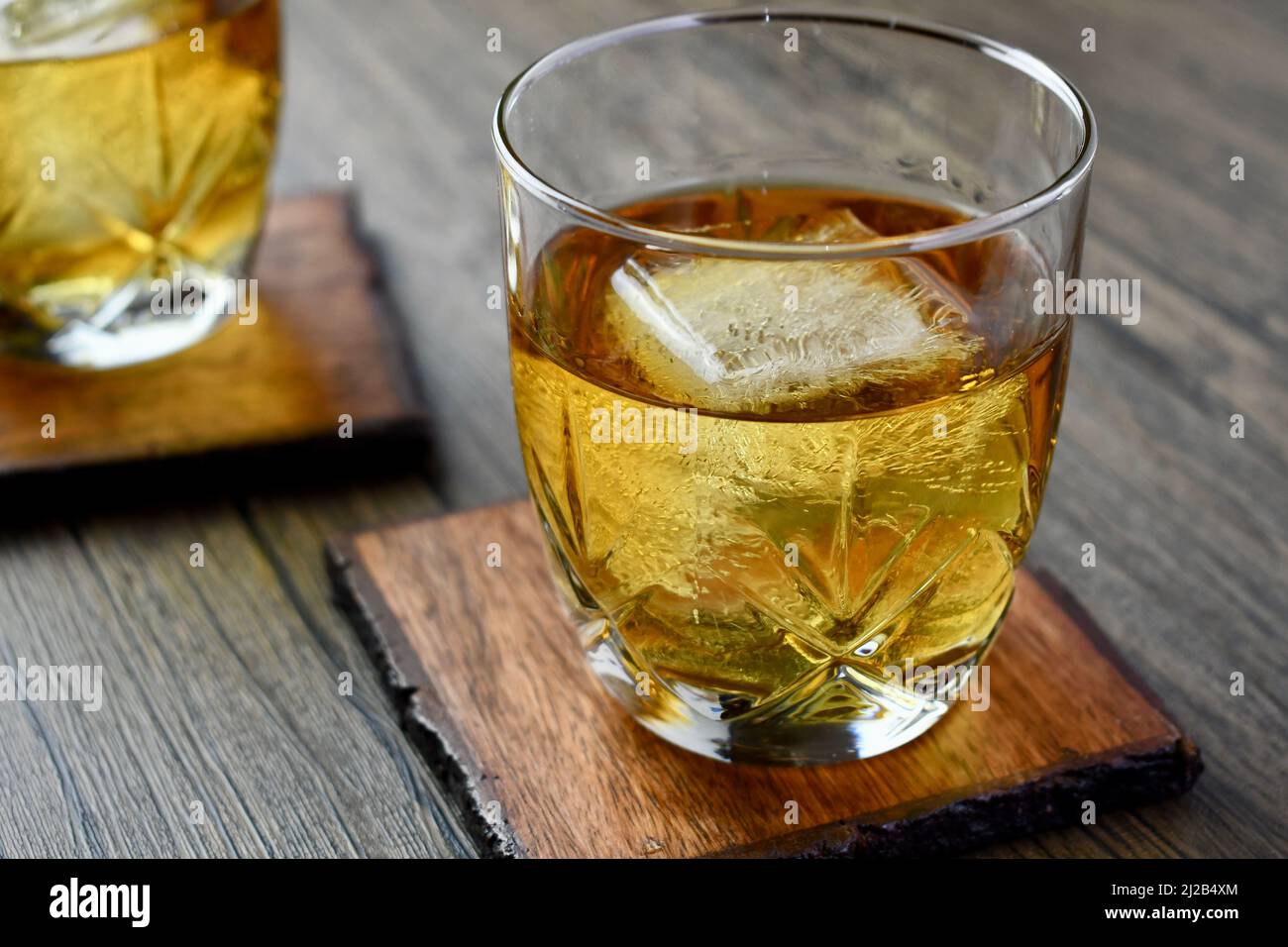 https://c8.alamy.com/comp/2J2B4XM/close-up-of-a-glass-of-bourbon-with-large-ice-cube-2J2B4XM.jpg