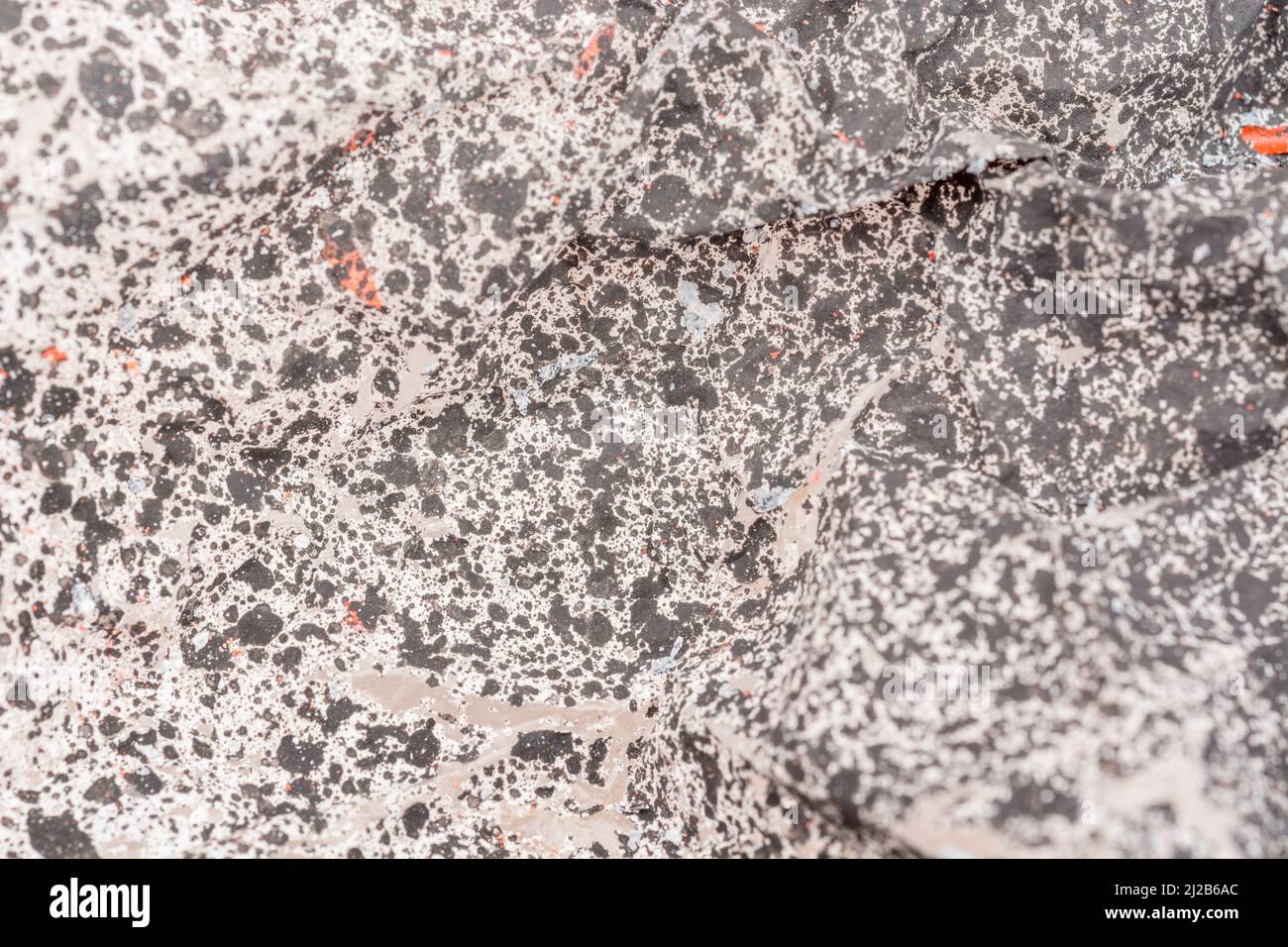 Close-up texture of paint covered plastic dust sheet covered by flaking paint spray. For peeling paint, making a mess of things. Stock Photo