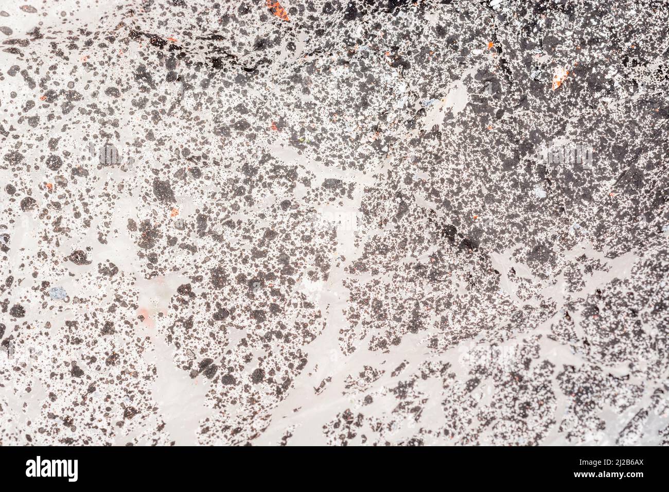 Close-up texture of paint covered plastic dust sheet covered by flaking paint spray. For peeling paint, making a mess of things. Stock Photo