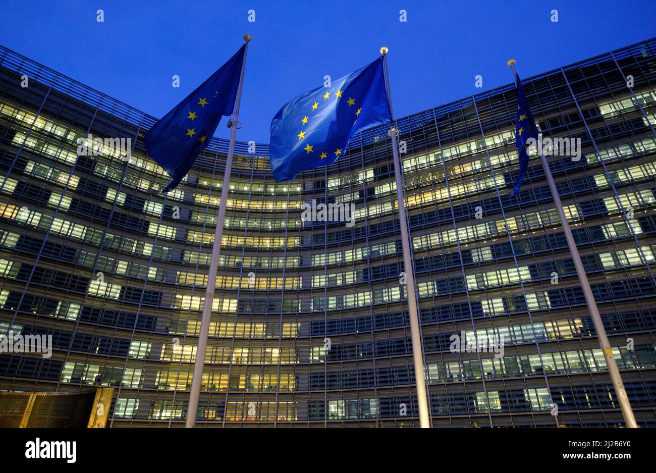 Belgium, Brussels: European Union Flags in front of the Berlaymont building, headquarters of the European Commission, in the evening Stock Photo