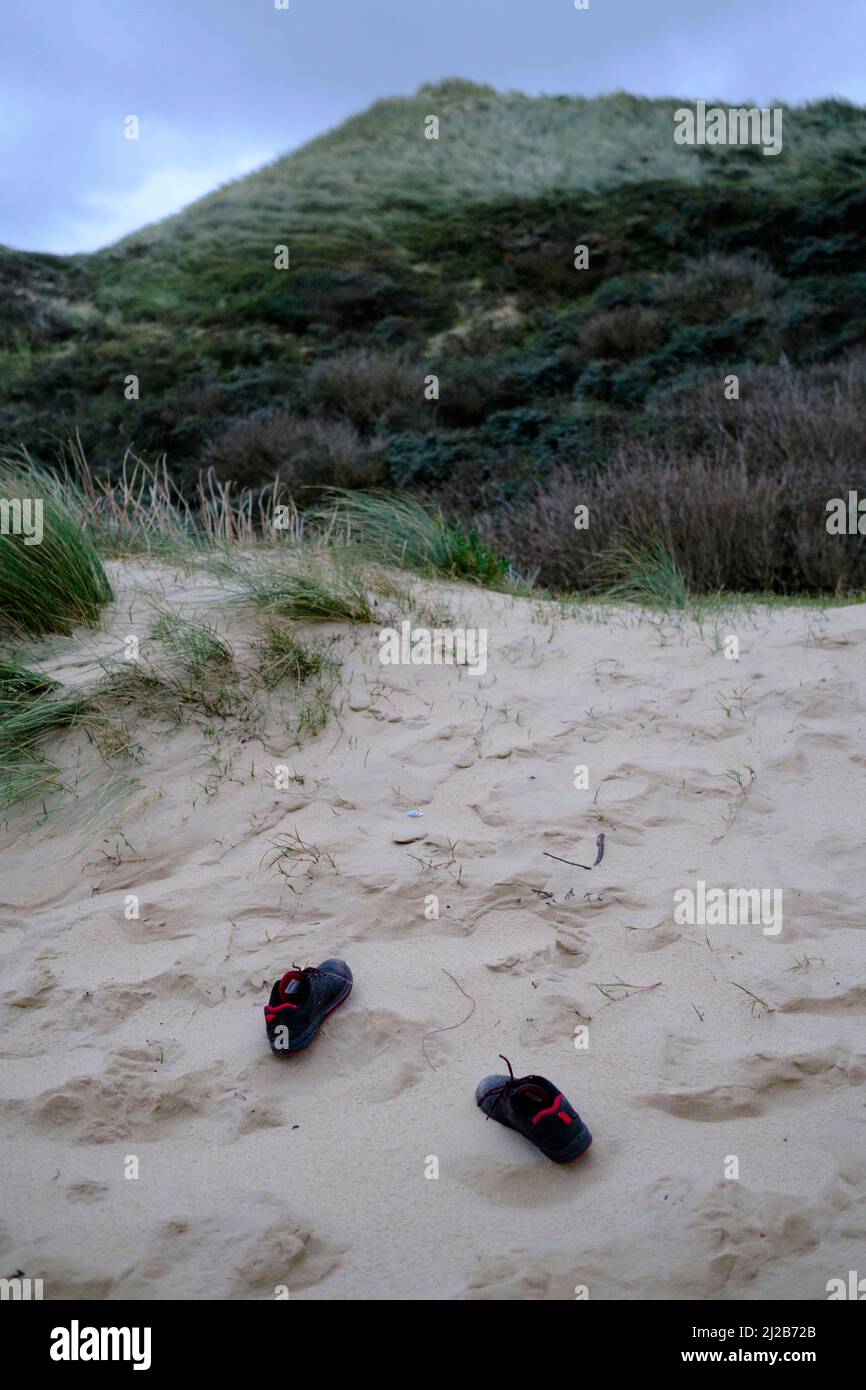 Refugees and migrants in the Hauts-de-France region (northern France), on November 26, 2021: refugee’s shoes on the beach and the upper part of the du Stock Photo