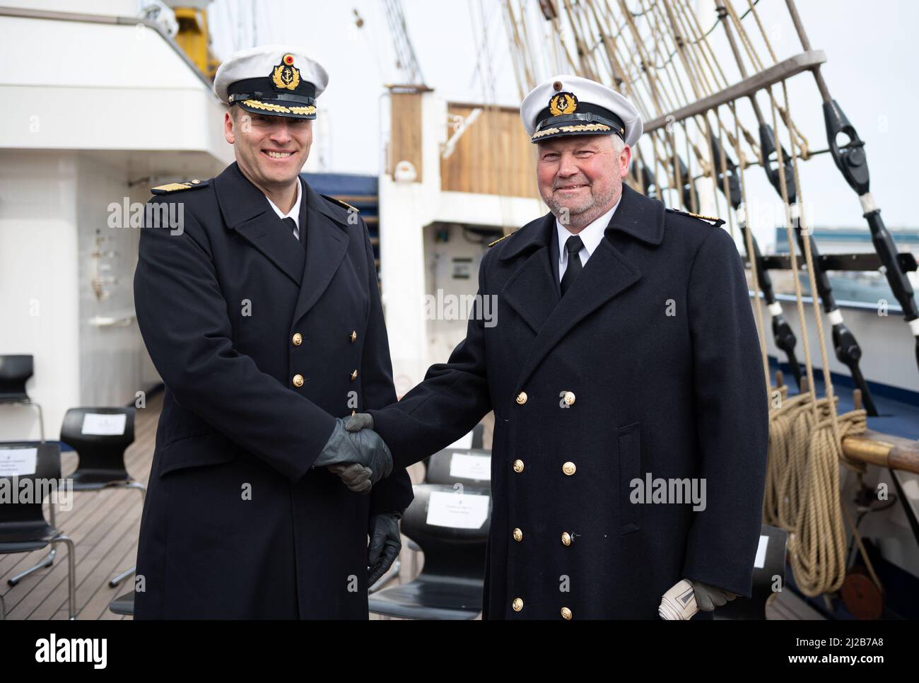 Kiel, Germany. 31st Mar, 2022. The new commander of the Gorch Fock, Captain (See) Andreas-Peter Graf von Kielmansegg (l), and his predecessor Captain (See) Nils Brandt, stand on board the ship after the handover of command. After eight years, Captain Brandt has handed over command of the sail training ship Gorch Fock to Captain Graf von Kielmansegg. Credit: Daniel Reinhardt/dpa/Alamy Live News Stock Photo