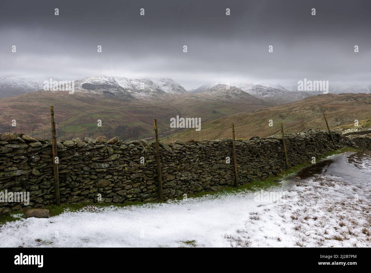 A snow capped Scandale Fell and Kirkstone Pass from Wansfell Pike in the Lake District National Park, Cumbria, England. Stock Photo