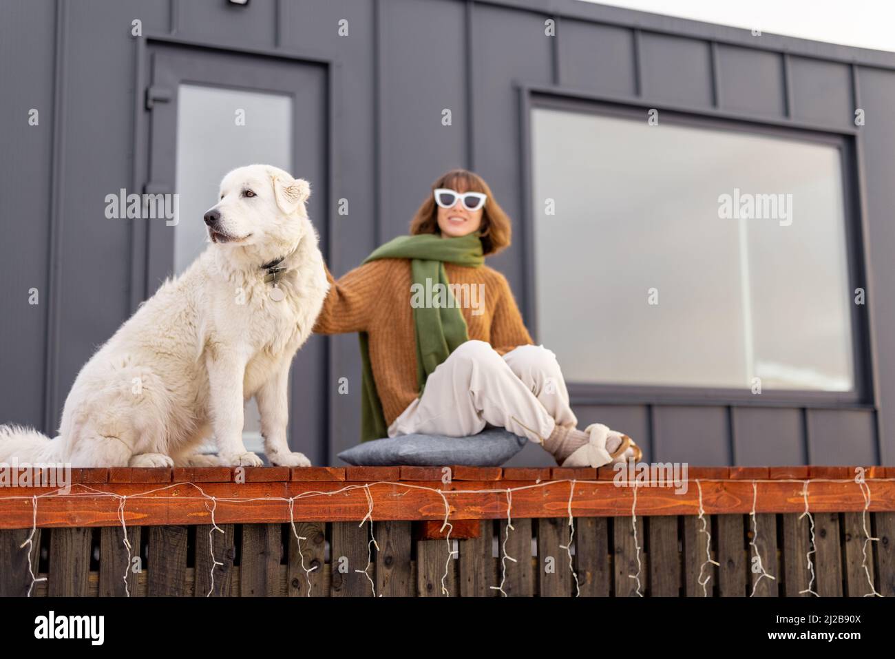 Woman with her dog resting on terrace of tiny house on nature Stock ...