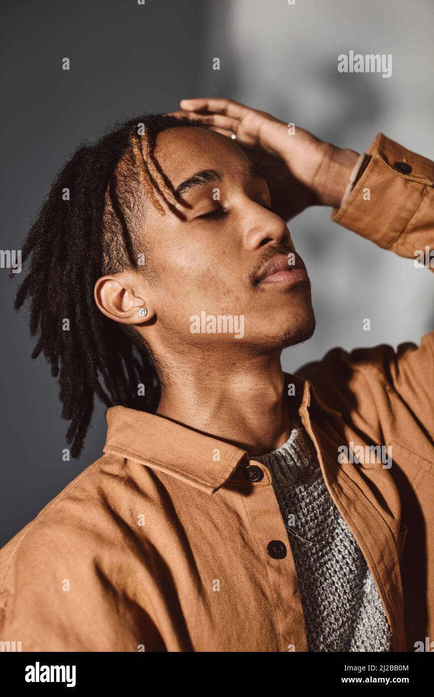 Young man with hand in hair at studio Stock Photo