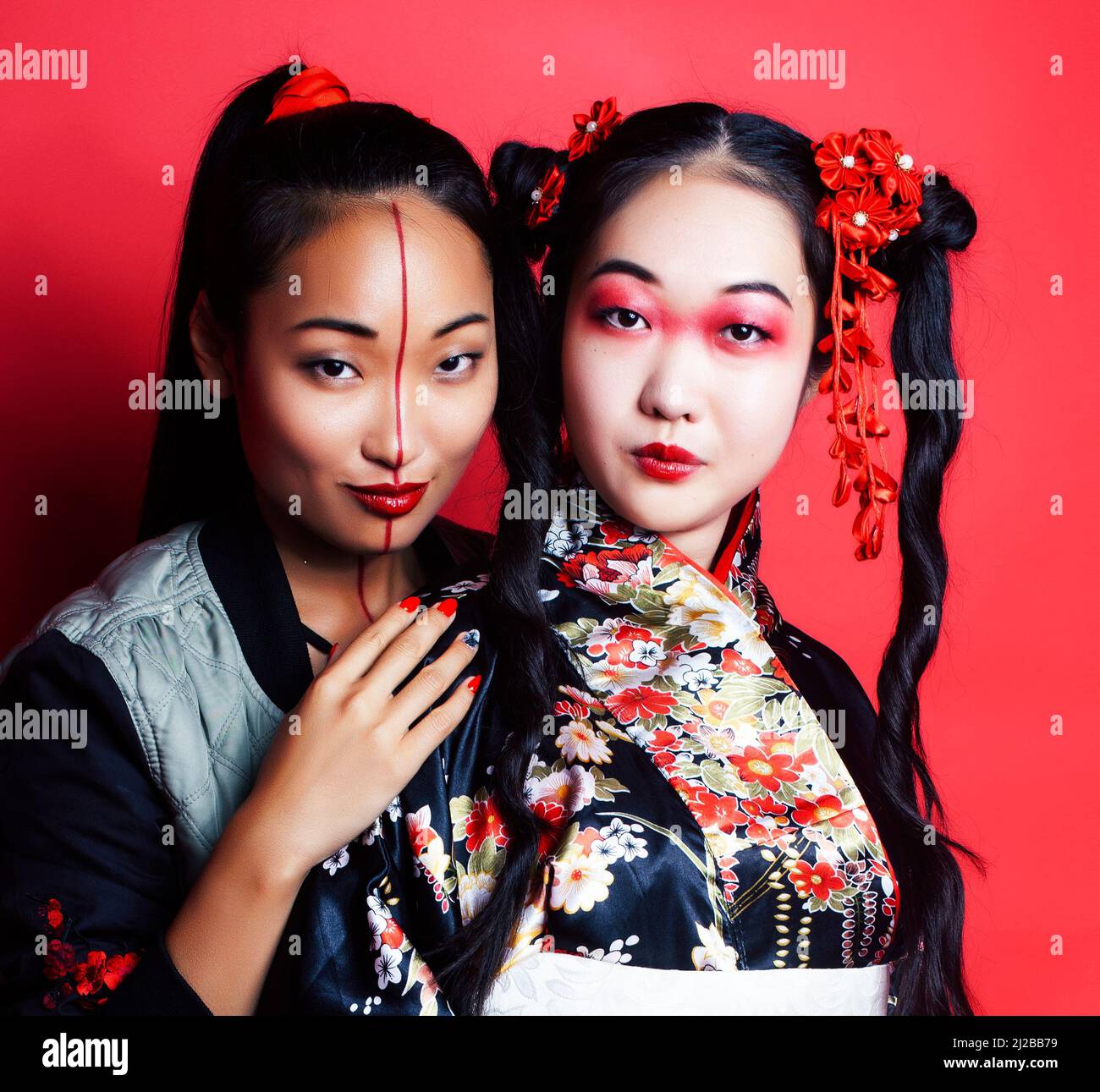 two pretty geisha friends: modern asian woman and traditional wearing ...