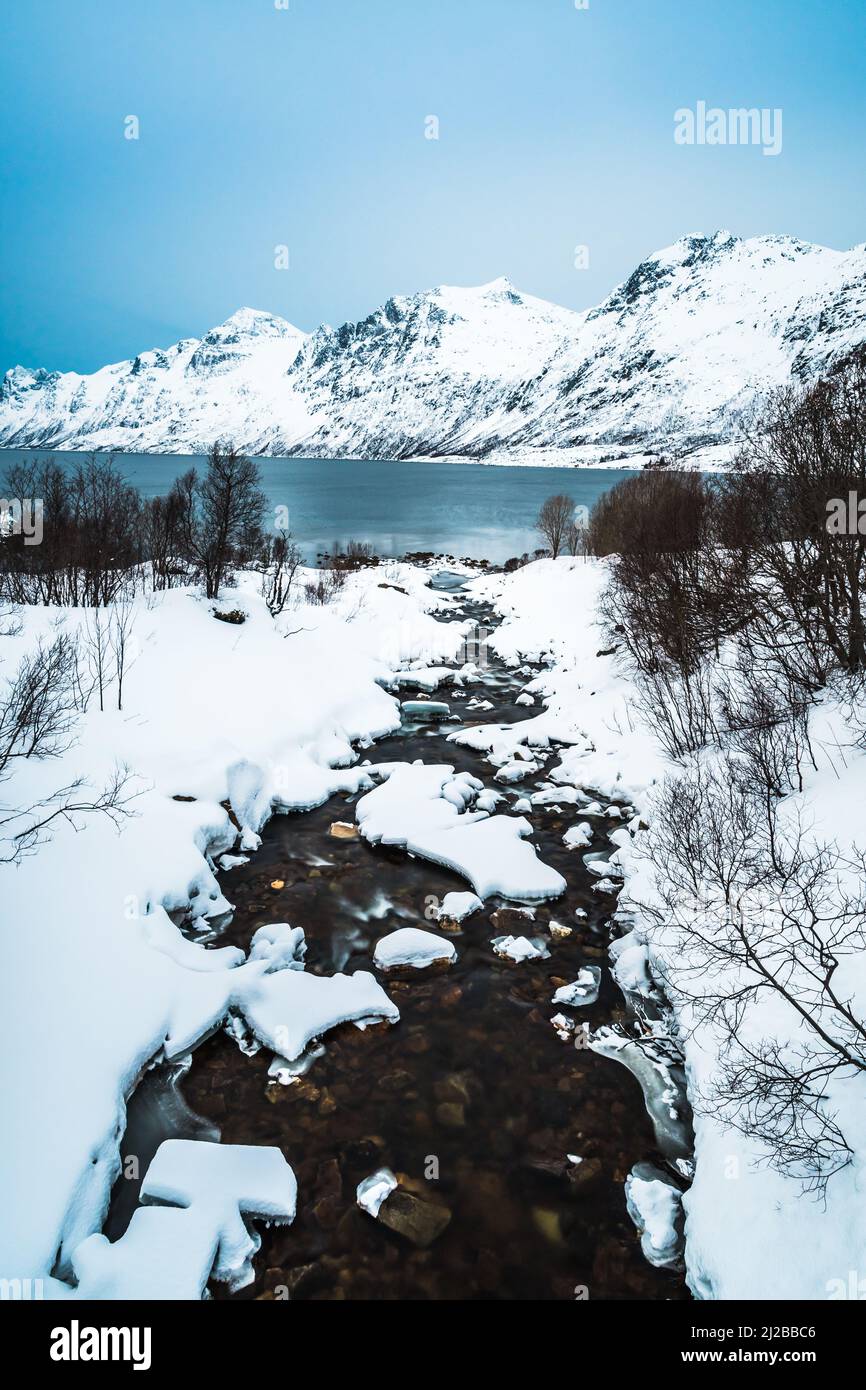 Ersfjordelva river which flows into Ersfjord, a Fjord in Northern Norway, close to Tromso in Troms County, Norway, on a cold winter afternoon. Vertica Stock Photo