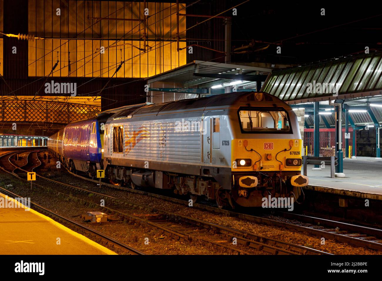 DB Schenker class 67 diesel locomotive 67026 at Carlisle railway station with a diverted East Coast train which it had hauled due to engineering work Stock Photo