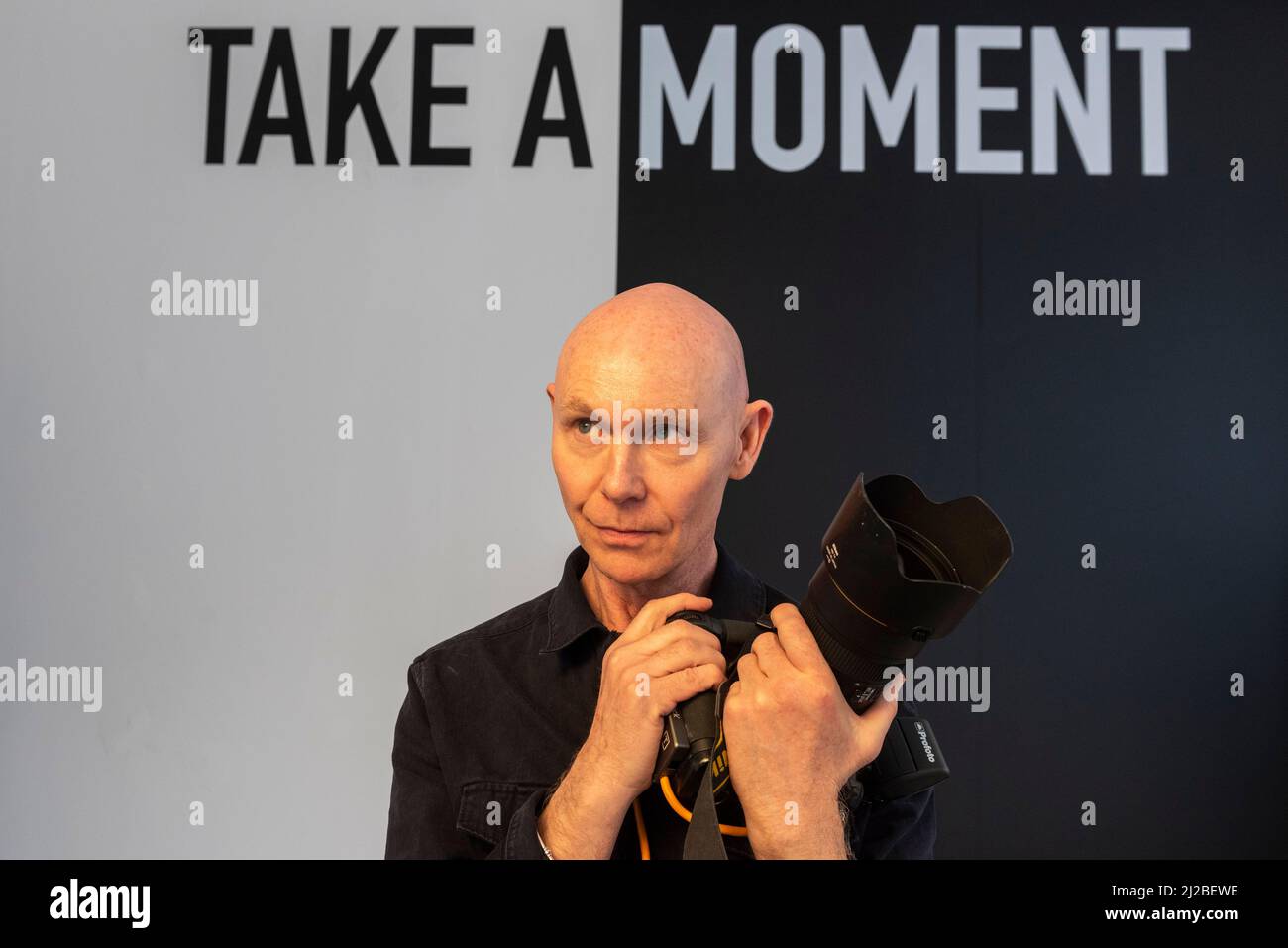 London, UK.  31 March 2022.  Photographer Ray Burmiston poses at his exhibition ‘Art of London Presents Take A Moment 2022’, displayed in a temporary gallery space beneath the Piccadilly Circus screens. Launched by NHS doctor and TV presenter, Ranj Singh, over one hundred A-list stars had their photo taken by Burmiston and closed their eyes on camera to pause, reflect, and raise awareness for mental health.  Credit: Stephen Chung / Alamy Live News Stock Photo