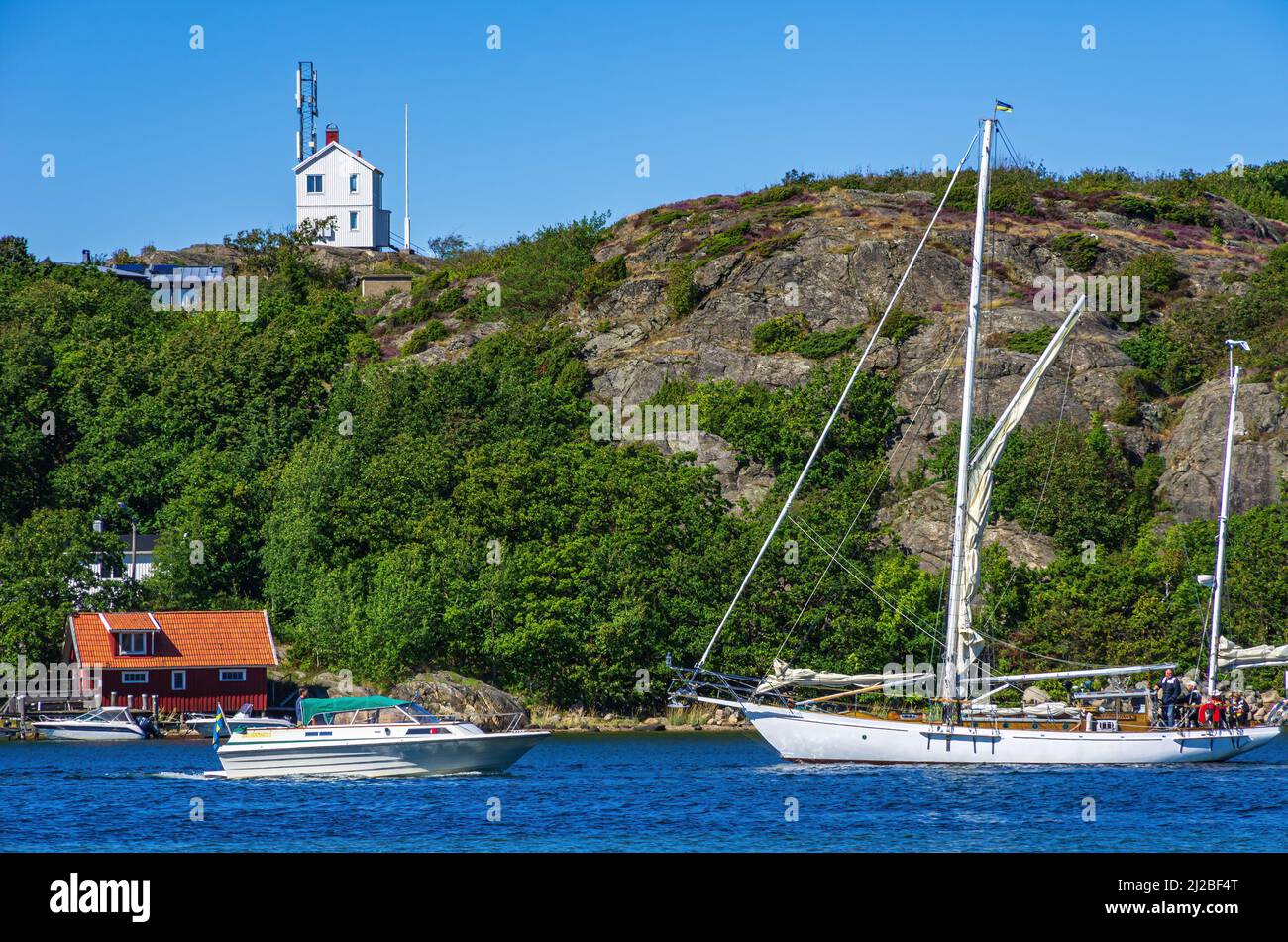 Picturesque coastal landscape with boat traffic and boat sheds, South coast of North Koster Island, Bohuslän, Västra Götalands län, Sweden. Stock Photo