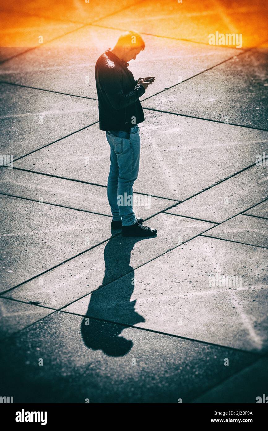 Man texting on a mobile phone in urban environment Stock Photo