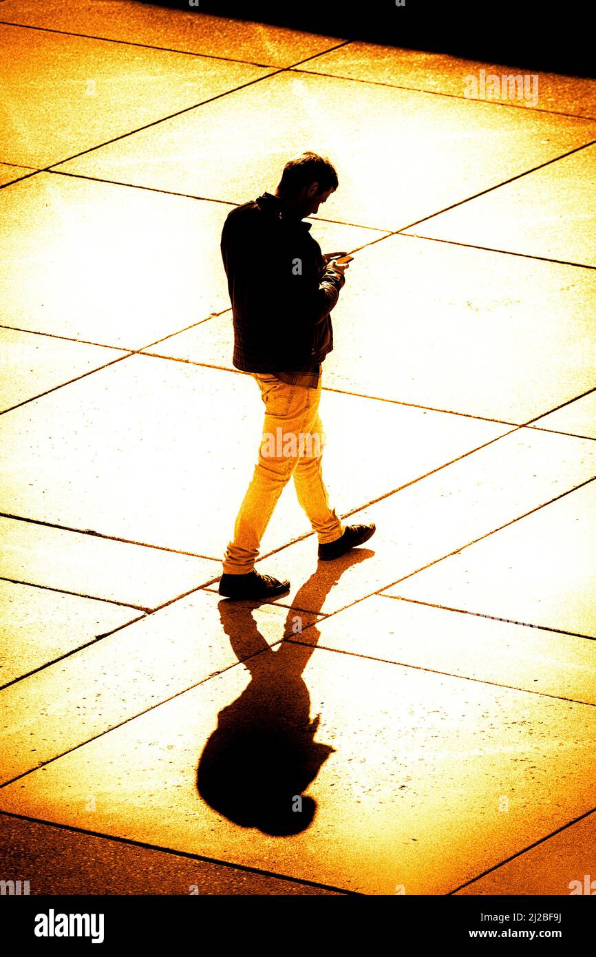 Man looking at smartphone while walking Stock Photo