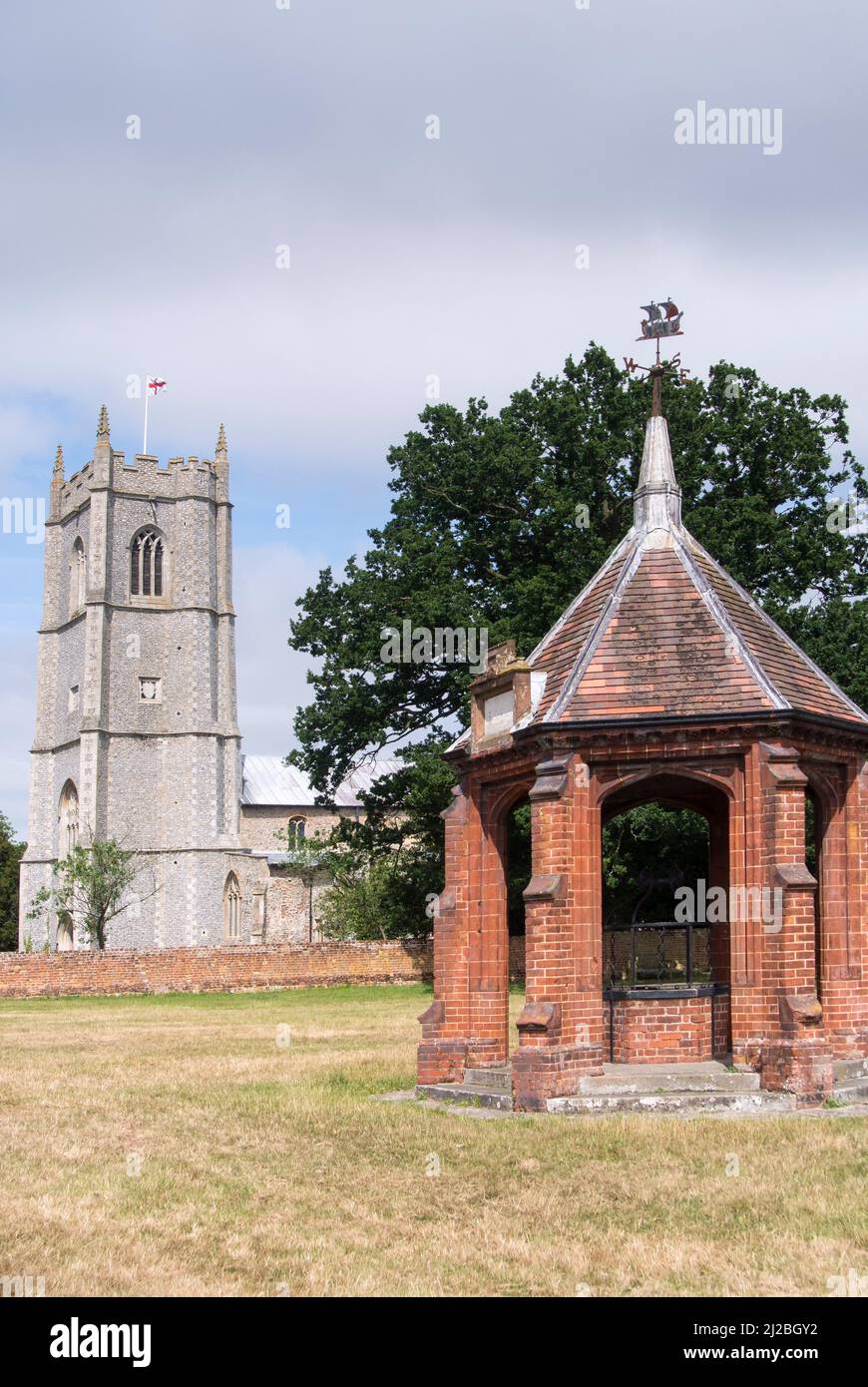 View of the church of St Peter and St Paul, and the covered village pump, Heydon Village, Norfolk, England Stock Photo
