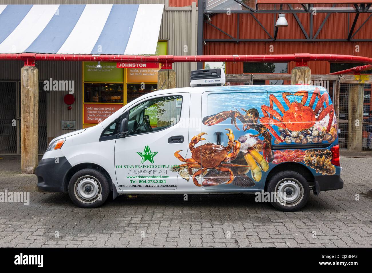 Seafood Delivery Van Nissan NV200 Compact Cargo Van Wrapped Advertising Tri-Star Seafood Supply Vancouver Canada At Granville Market Stock Photo