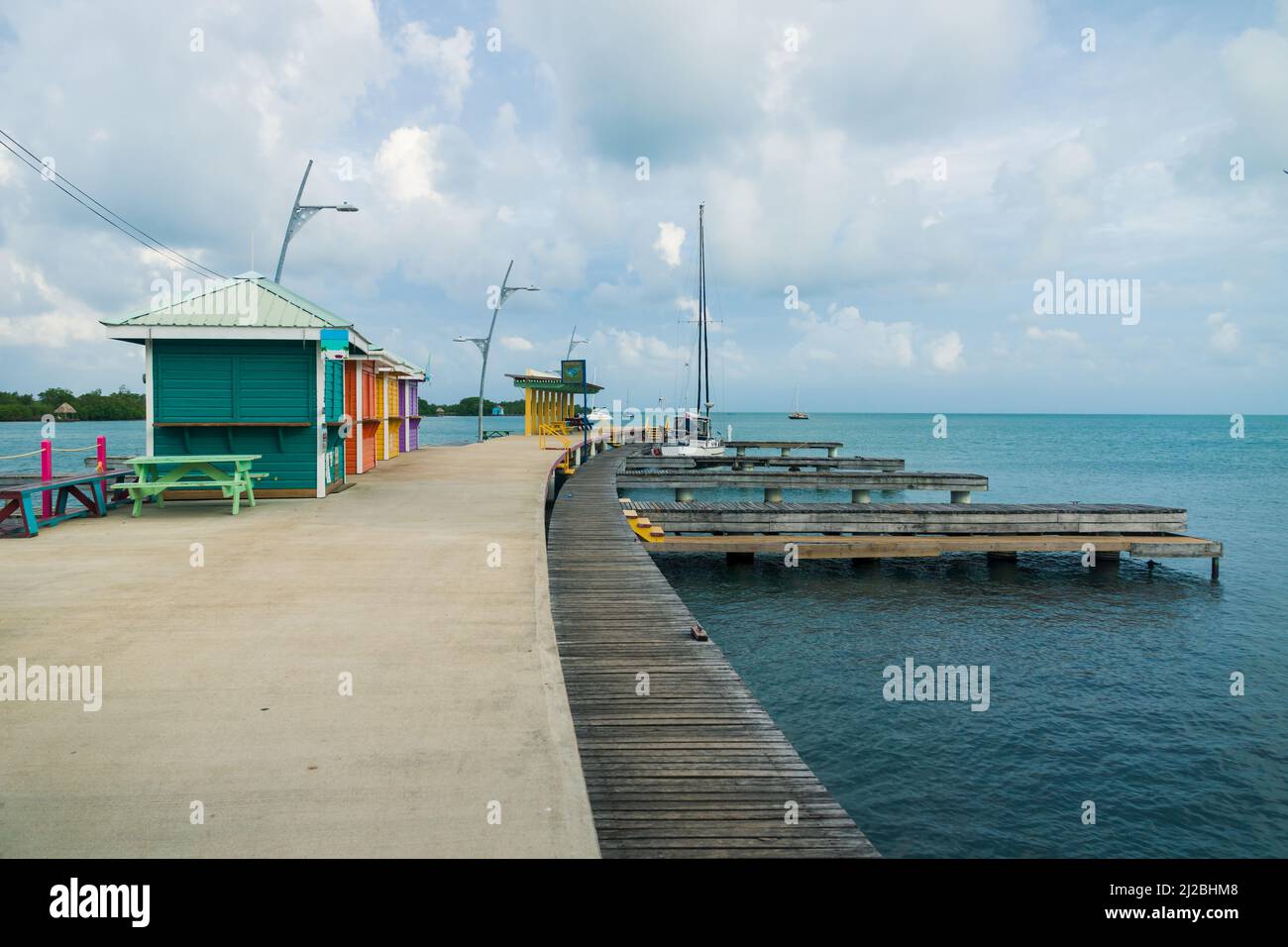 Colorful huts at the wooden boat dock at the harbor of Placencia, Belize Stock Photo