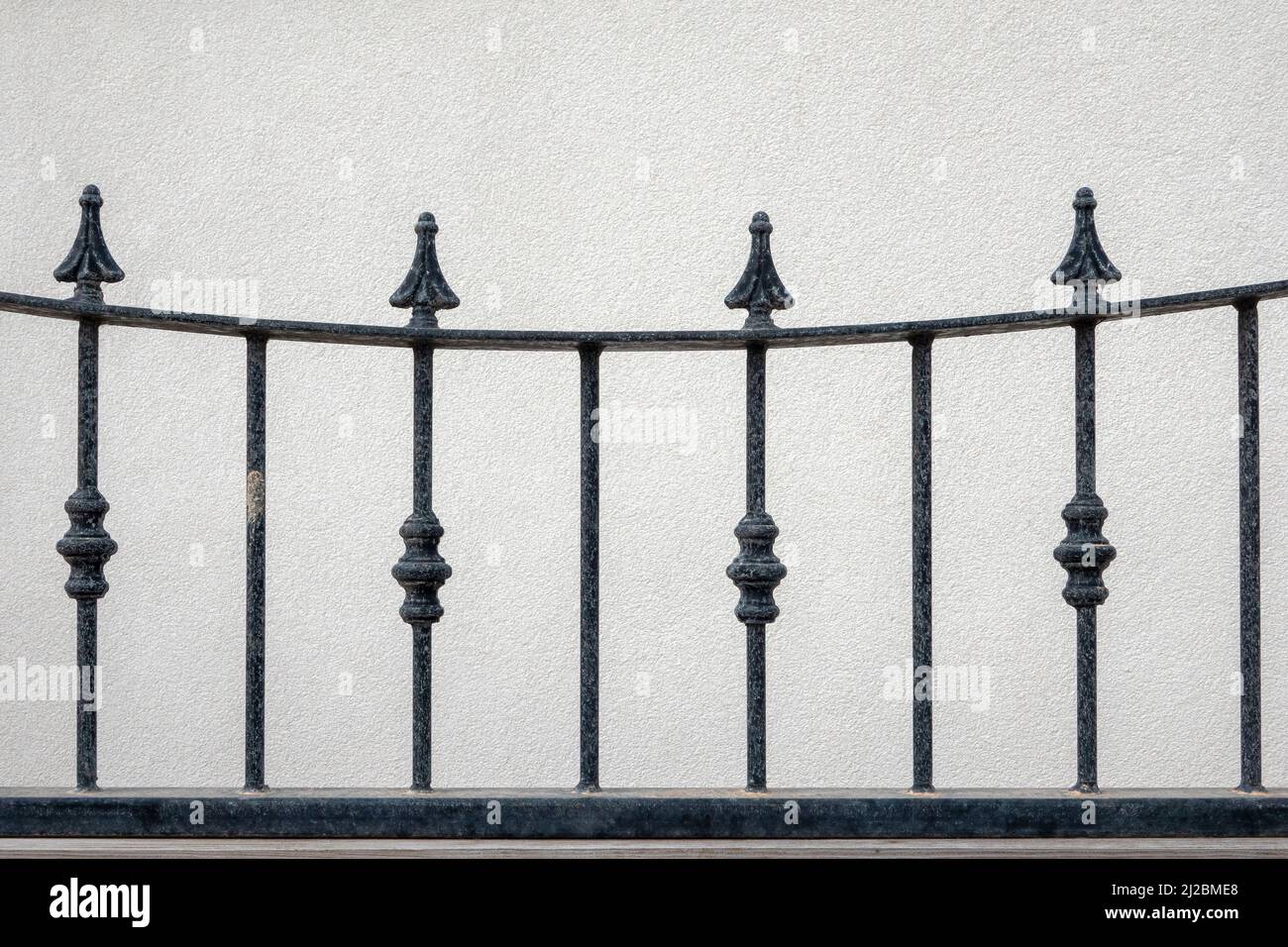 Short length of domestic metal railings against a white wall Stock Photo