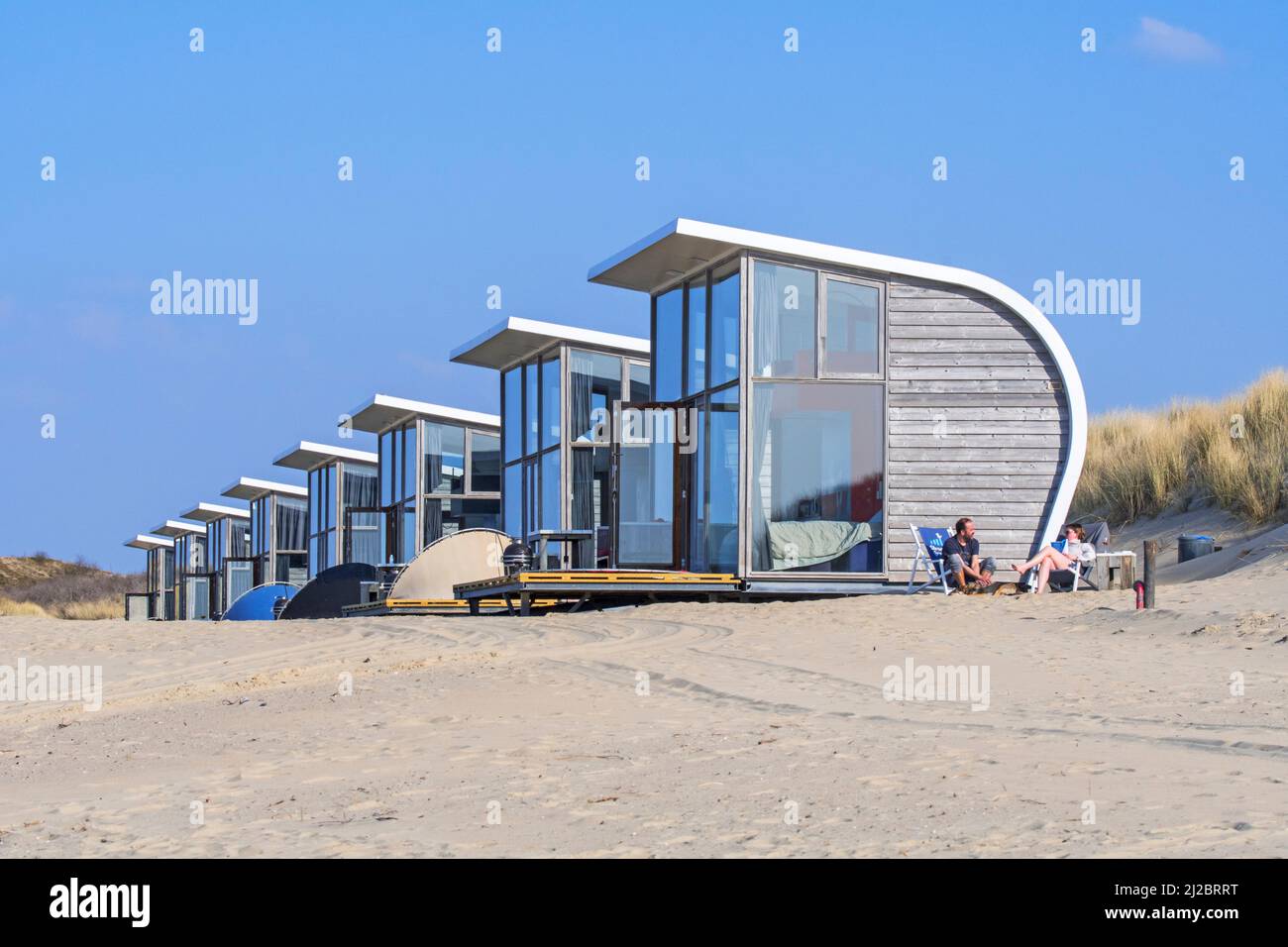Row of tiny houses / beach houses for rent on sandy beach along the