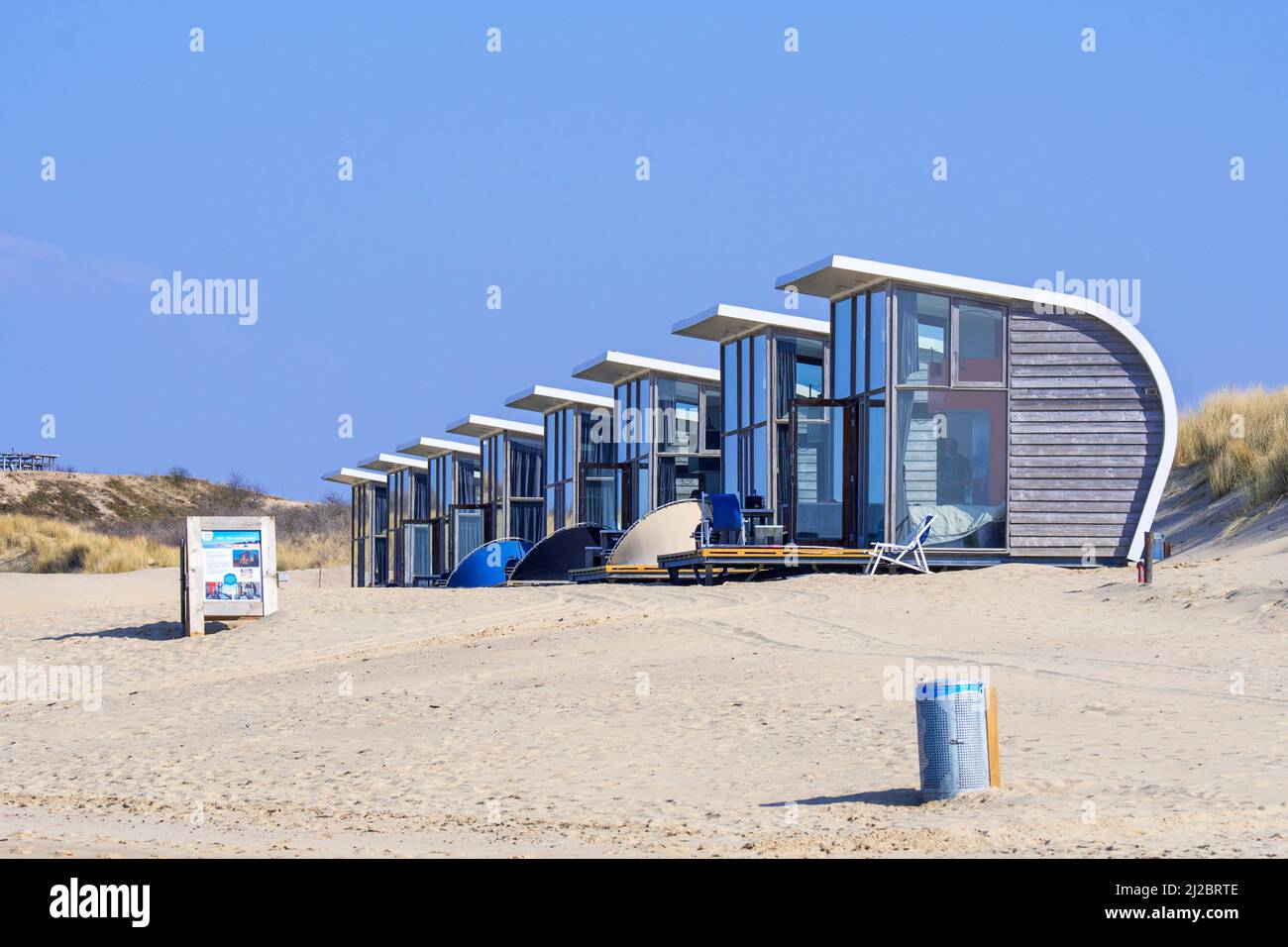 Row of tiny houses / beach houses for rent on sandy beach along the