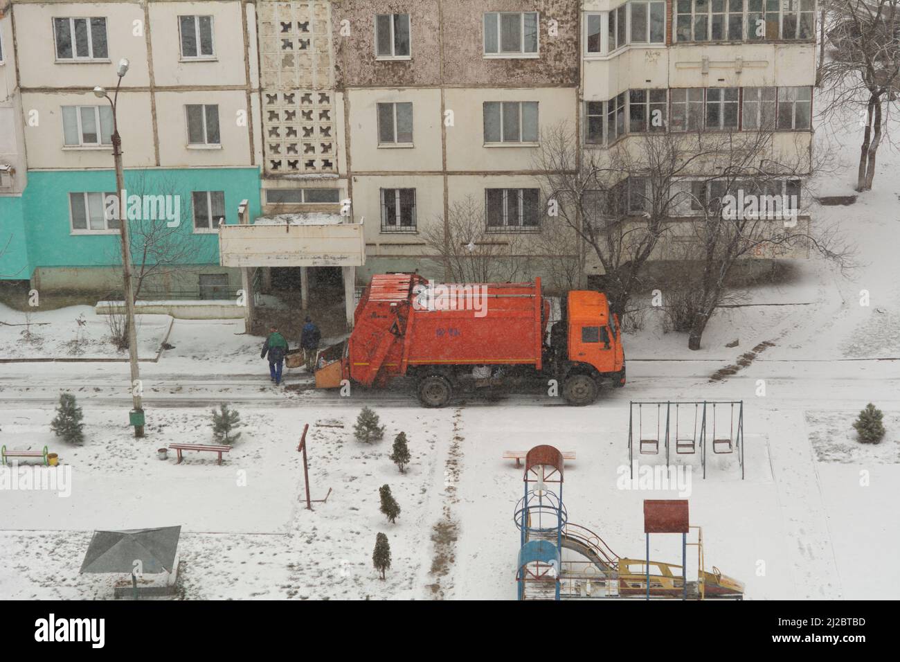 Garbage truck workers. Garbage removal in residential area, garbage men loading household rubbish in garbage truck Stock Photo