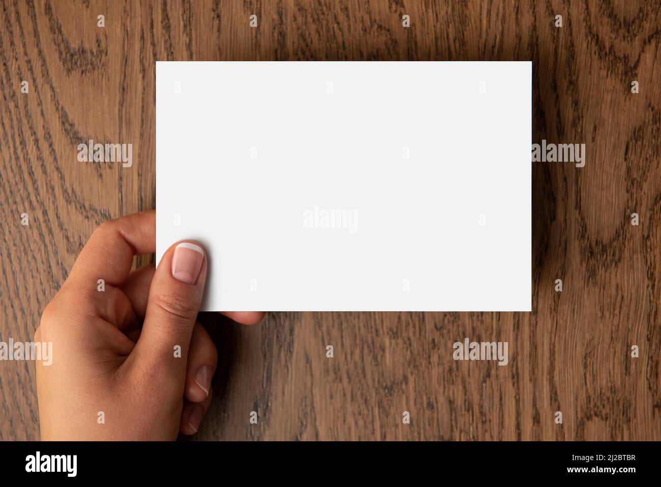 Woman's hand holding blank paper with a space for text Stock Photo