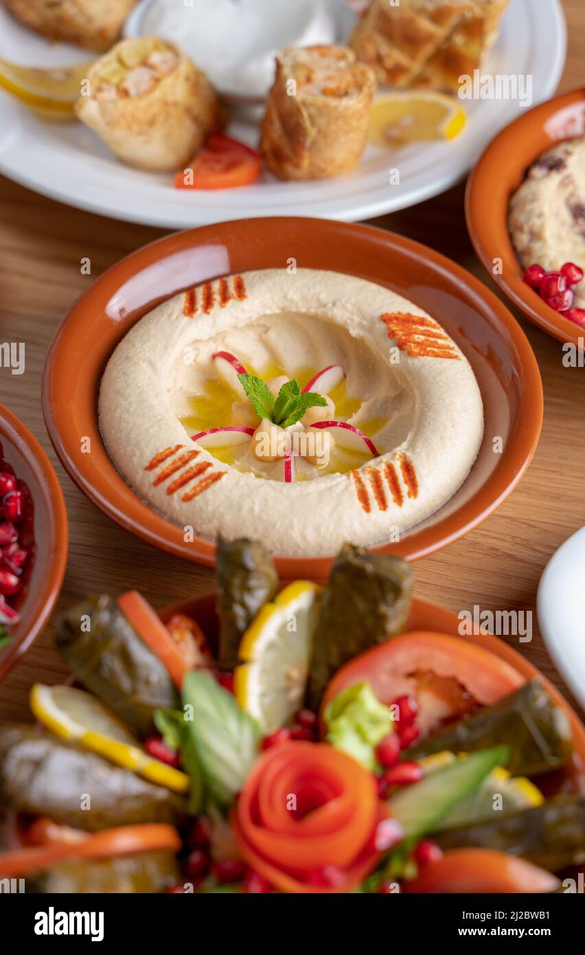 Multiple lebanese appetizers and salads togeather on the table. focused on hummus Stock Photo
