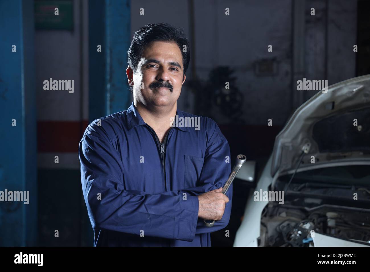 A man with a mustache in a blue shirt when building a car in Navneet