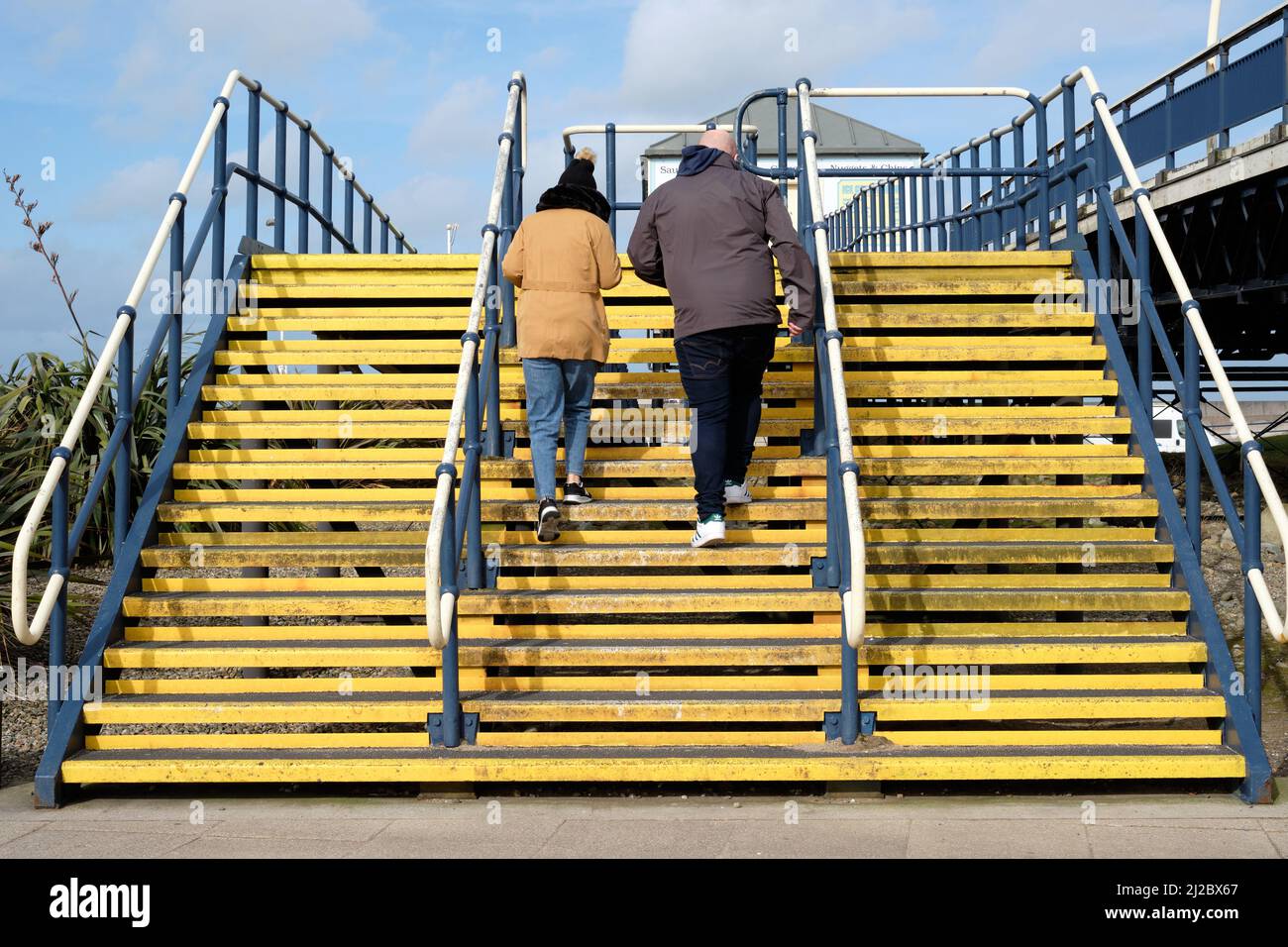 Couple climbing Yellow Stairs Stock Photo