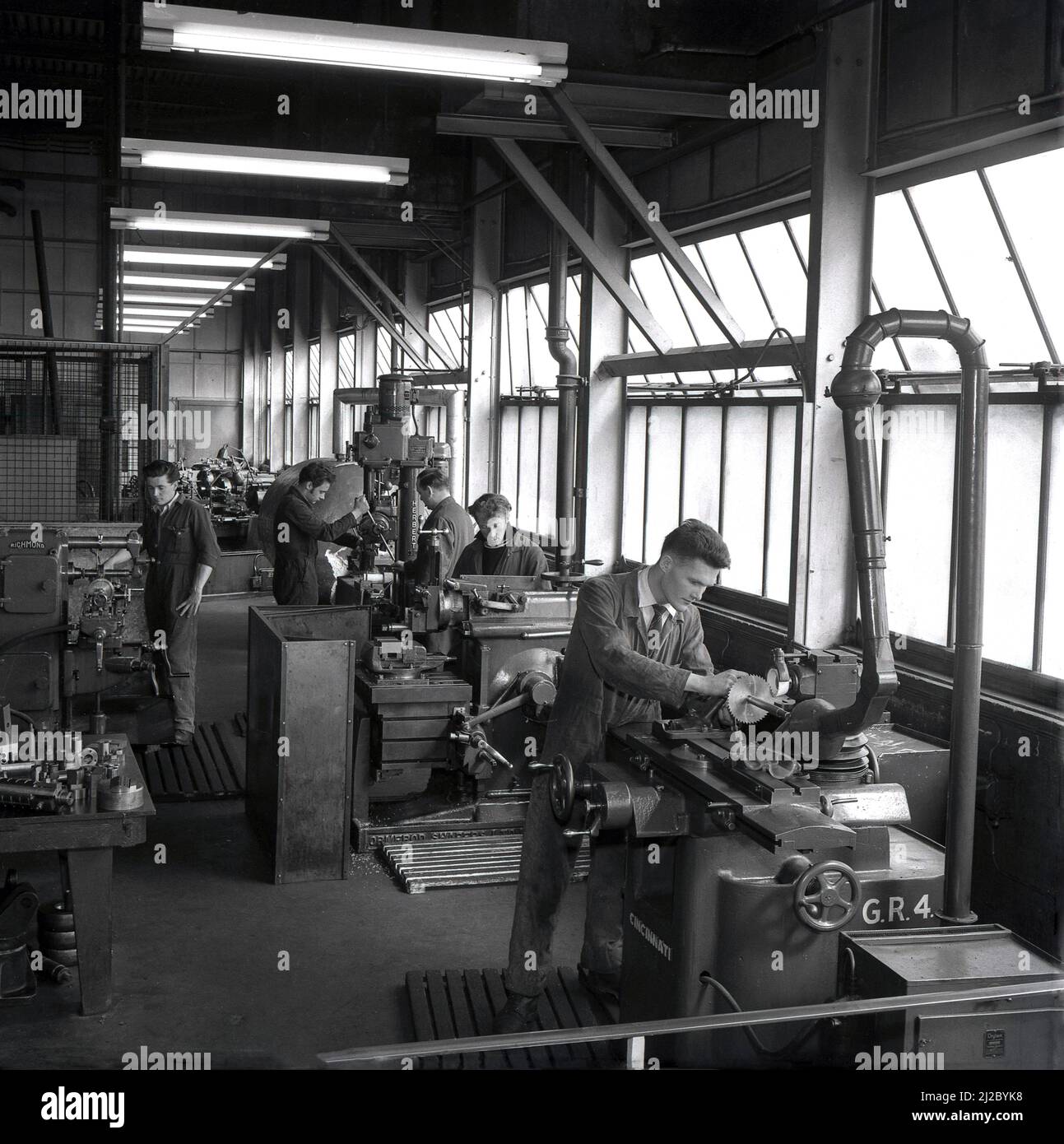 1950s, historical, Abbey Works, Port Talbot, Wales, UK. Young men working with the lathes and metal working machinery of the day, with supervisor in attentance. Herbert, CIncinnati, Drytex, and Richmond are some of the manufacturers names on the machine tool machinery being used in the workshop. Stock Photo