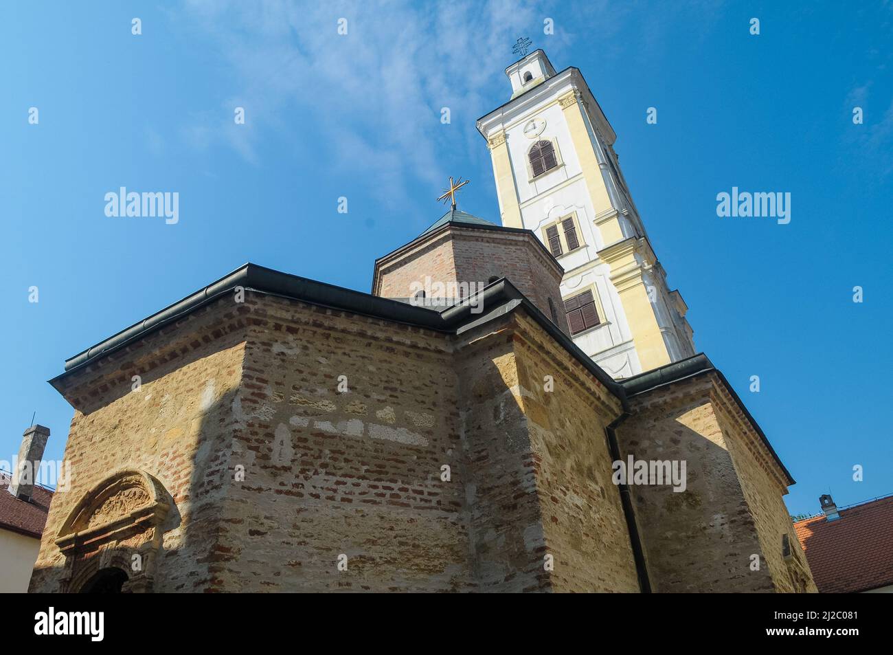 A low angle shot of a medieval church with white walls under the blue ...