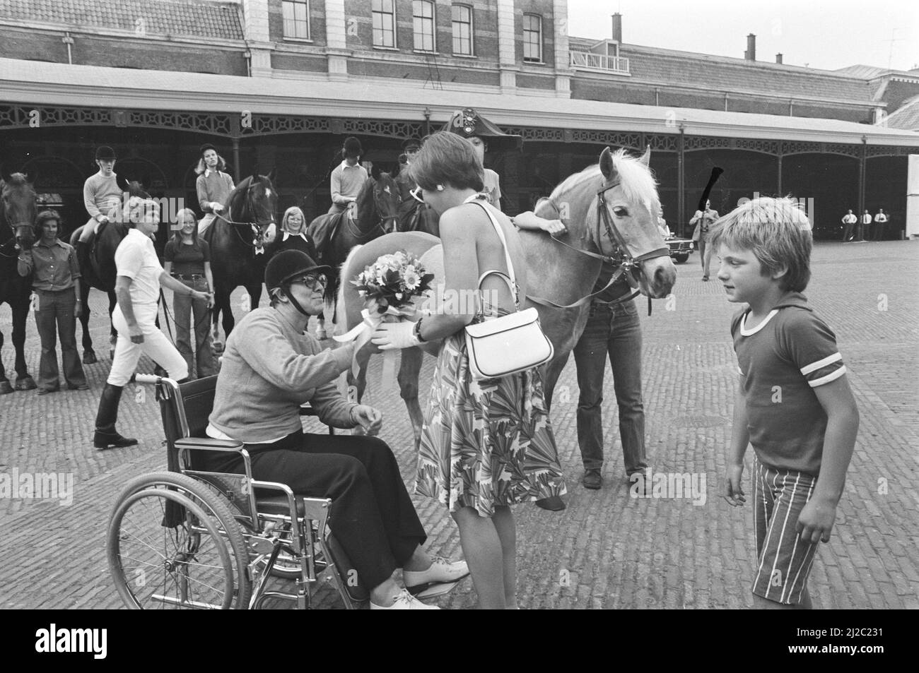 Margriet and Maurits at a demo horseback riding for the disabled in The Hague, Margriet receives flowers from a woman in a wheelchair, right Prince Maurits / ca. 9 June 1976 Stock Photo