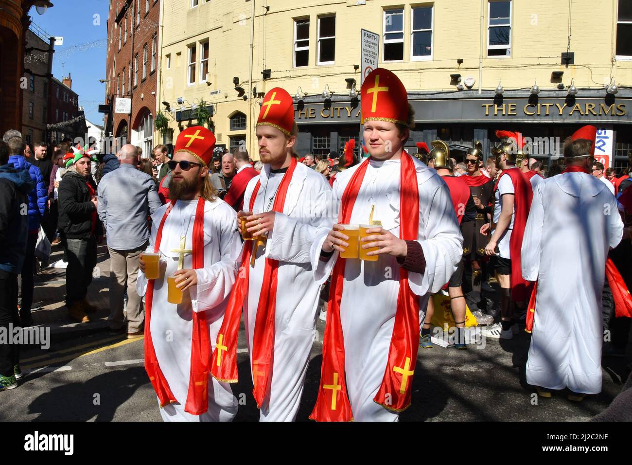 Cardiff, Wales - March 2022: Rugby supporters dressed as bishops carrying pints of beer in Cardiff city centre on day of an international rugby match Stock Photo