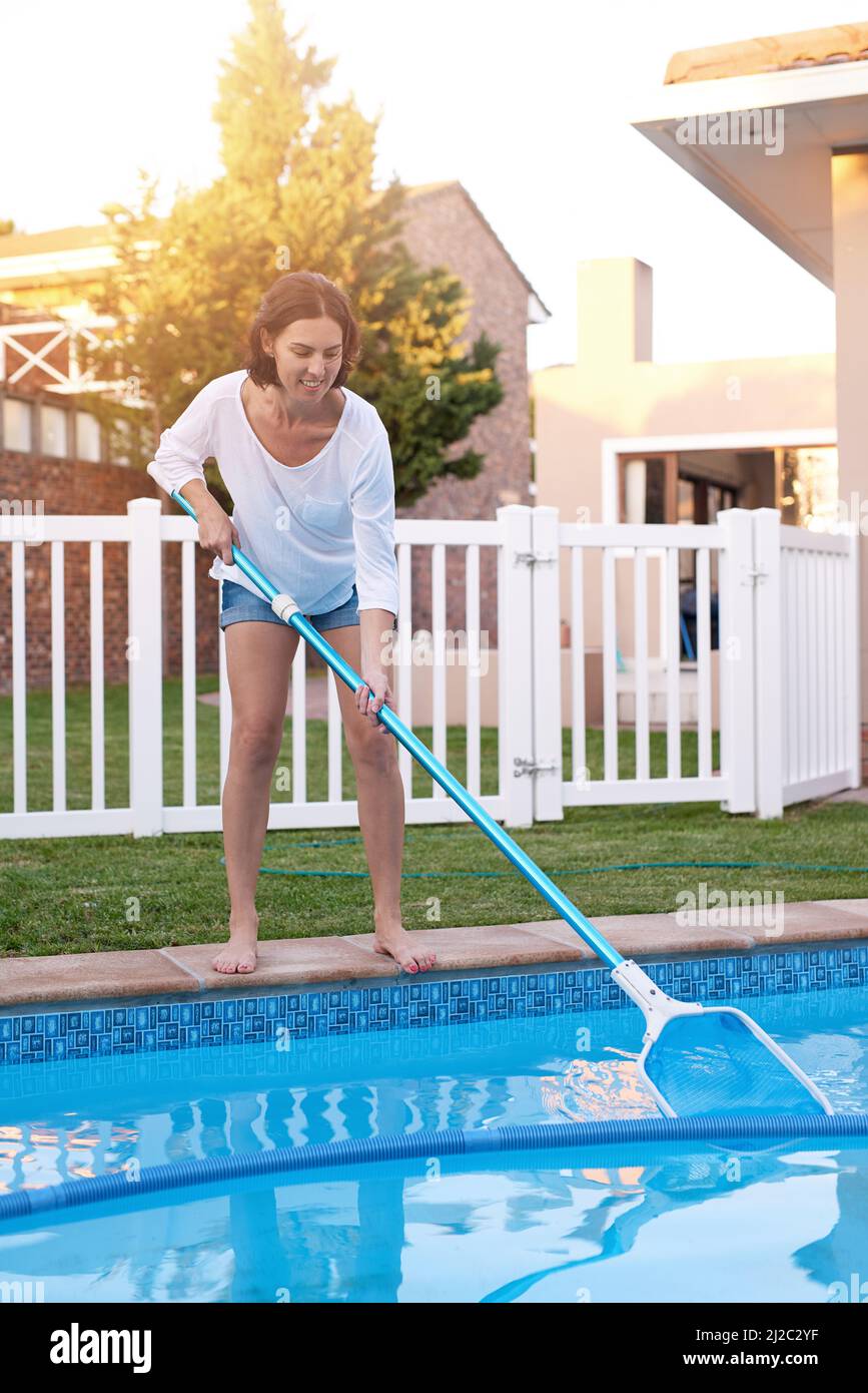 Cool by the pool. Shot of a young woman cleaning a pool Stock Photo Alamy