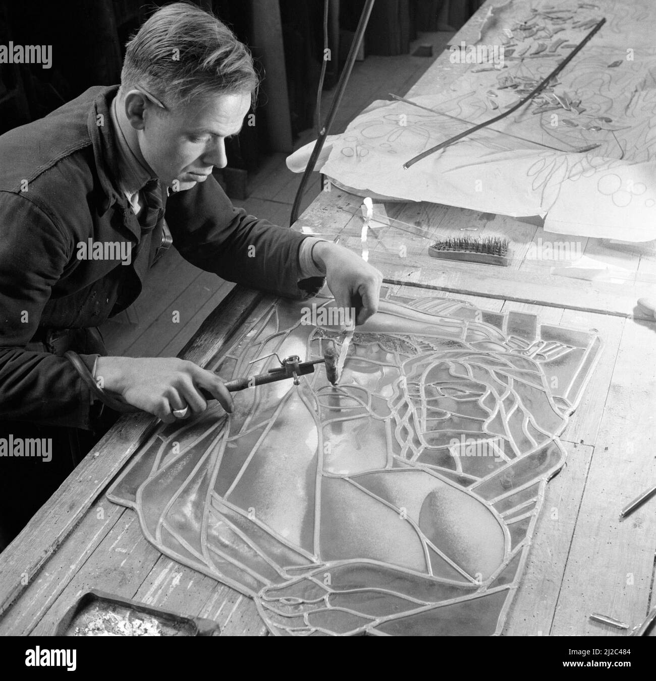 Soldering a stained glass window ca 1948 Stock Photo Alamy