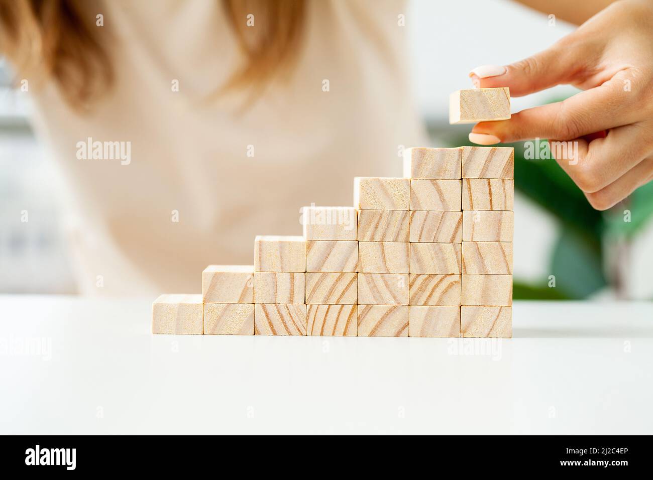 Hand arranging wood cube stacking as stair step shape Stock Photo - Alamy
