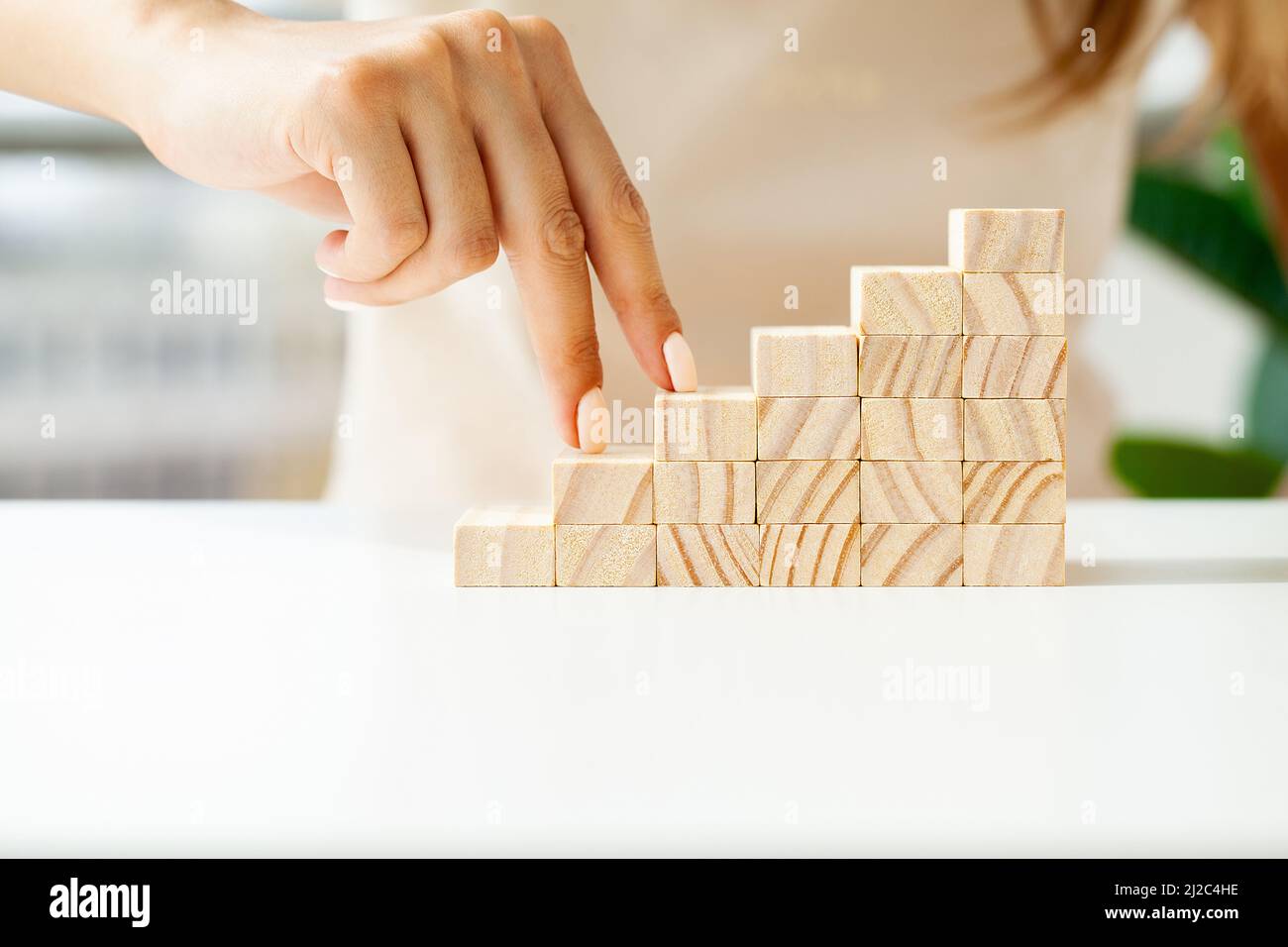 Hand arranging wood cube stacking as stair step shape Stock Photo - Alamy