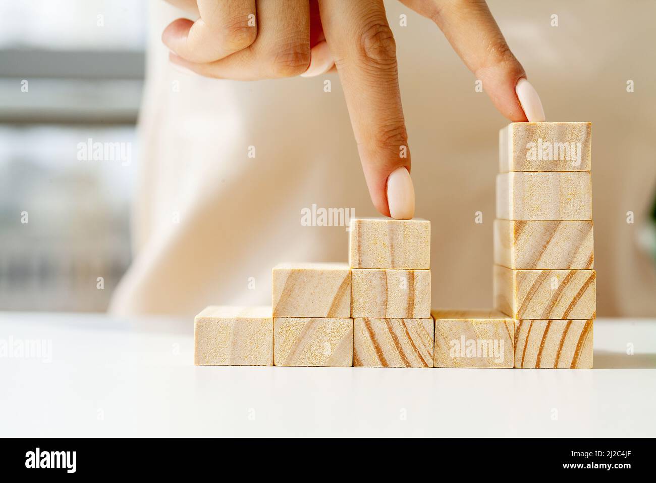 Hand arranging wood cube stacking as stair step shape Stock Photo - Alamy
