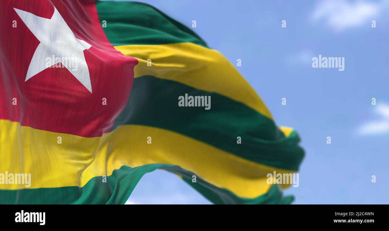 Detail of the national flag of Togo waving in the wind on a clear day. Togo is a country in West Africa. Selective focus. Stock Photo