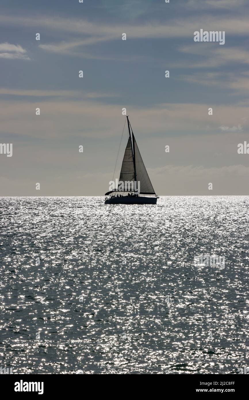 Segelschiff im Gegenlicht - Symbolbild für Freiheit und Fernweh, Jandia Playa, Fuerteventura, Spanien Stock Photo