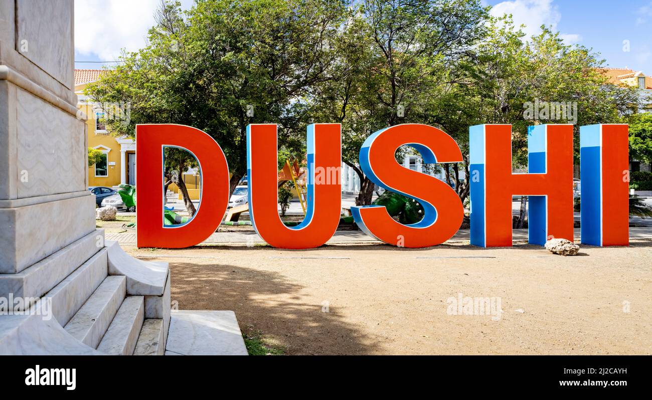 DUSHI written in big red and blue letters in the city center of Willemstad Stock Photo