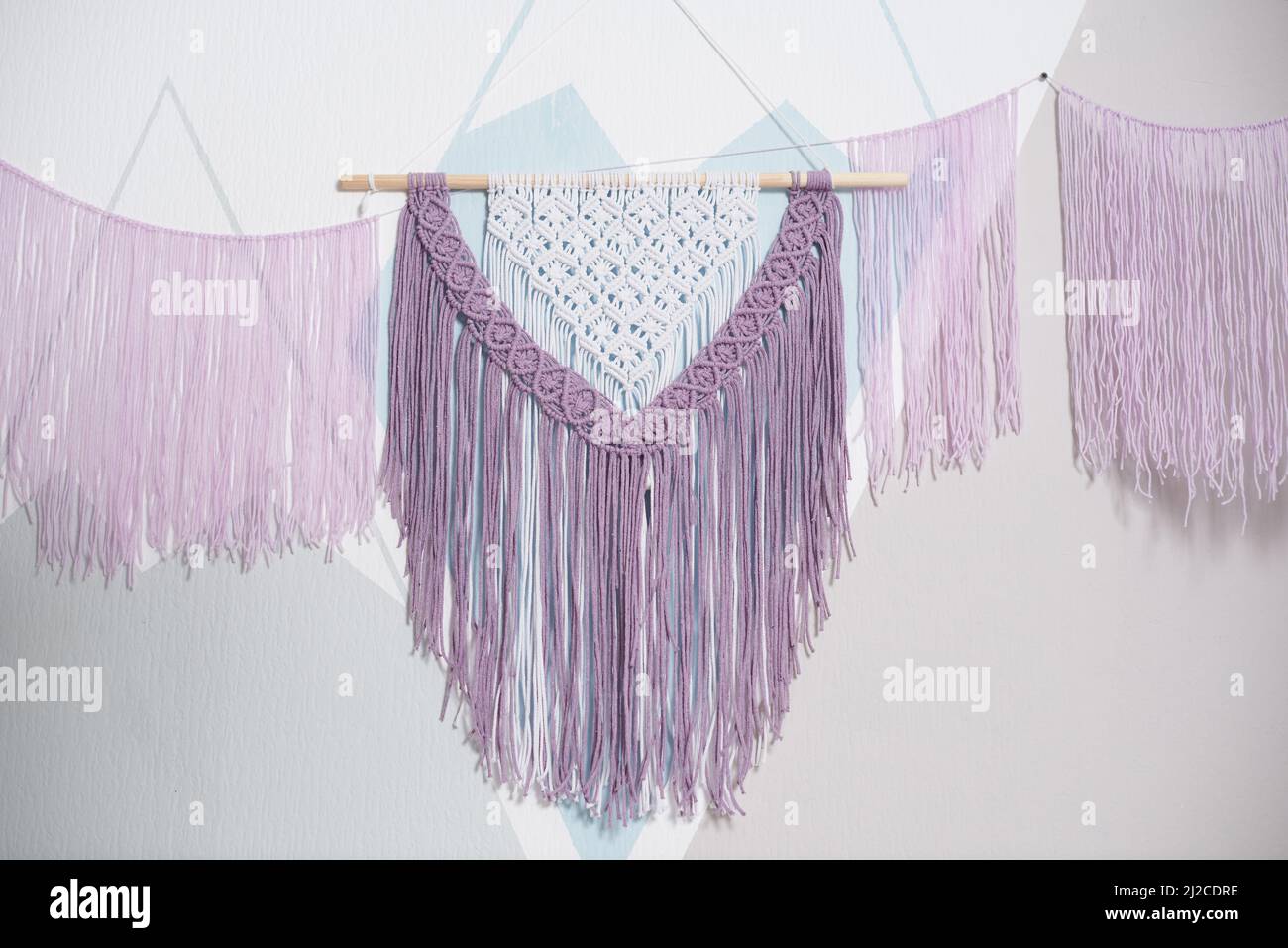 Pink macrame on the wall for interior in boho style Stock Photo