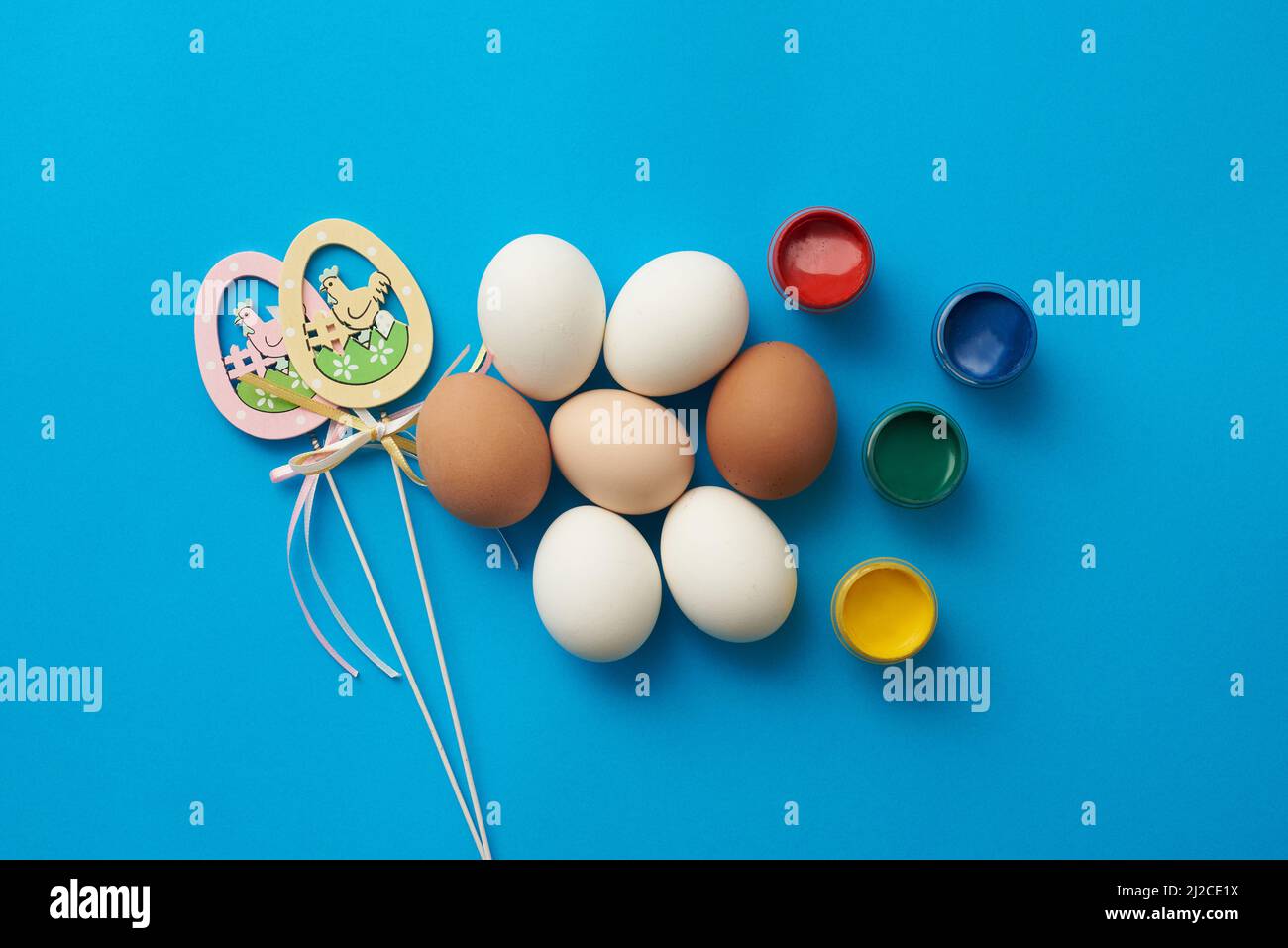 Easter theme template with chicken eggs and paints on a blue background Stock Photo